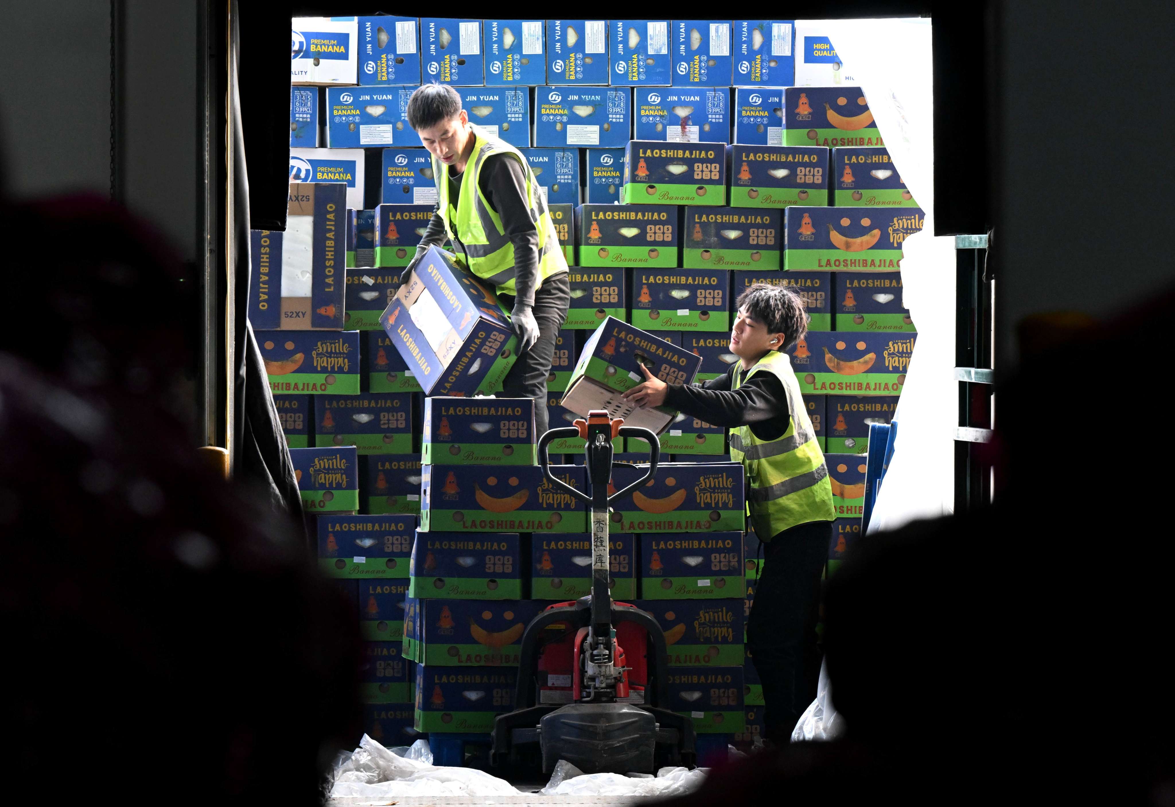 Staff members unload fruit from a truck at a logistic industrial park in Shijiazhuang. Photo: Xinhua