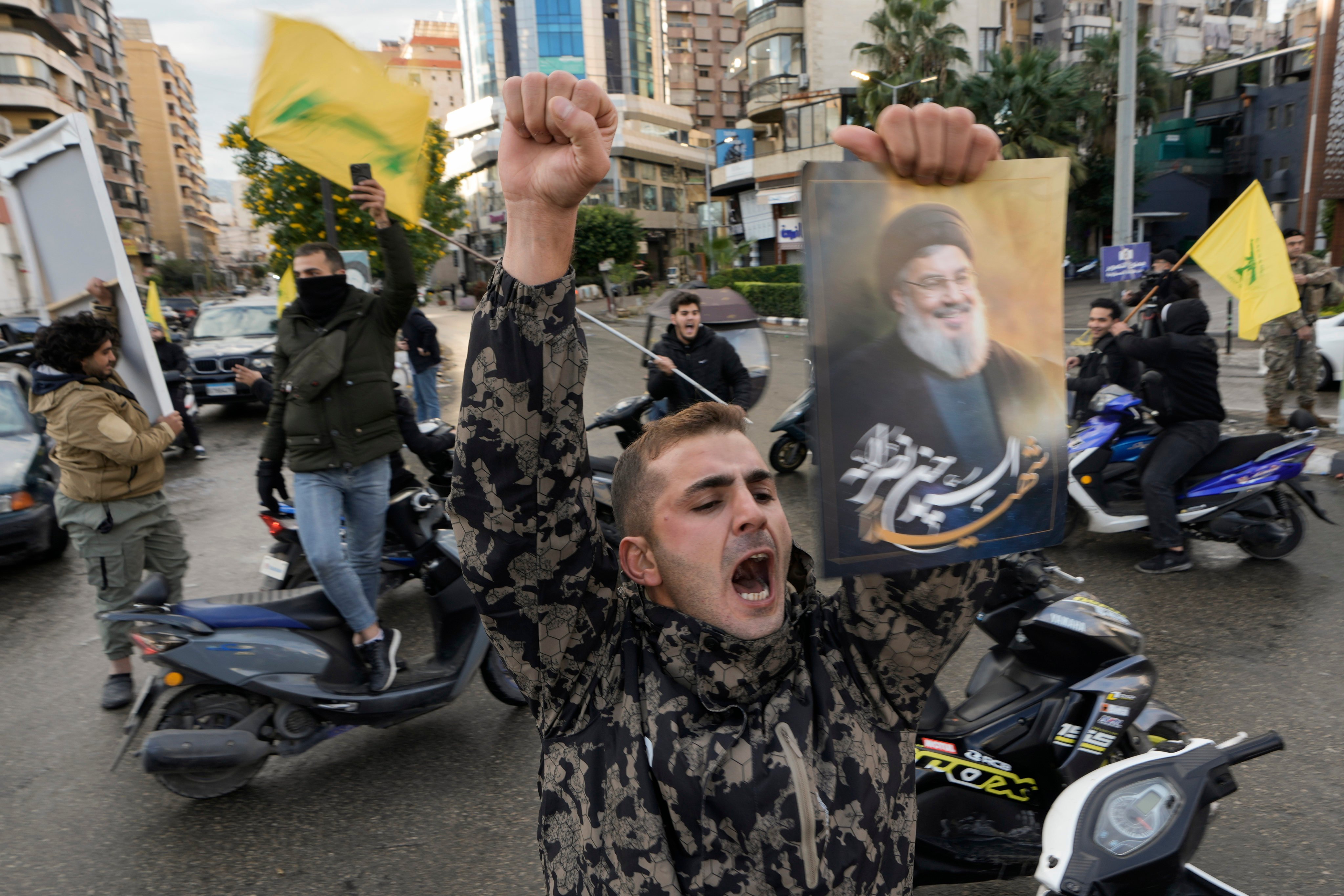 A man carrying a picture of slain Hezbollah leader Hassan Nasrallah celebrates in Beirut following the ceasefire. Photo: AP