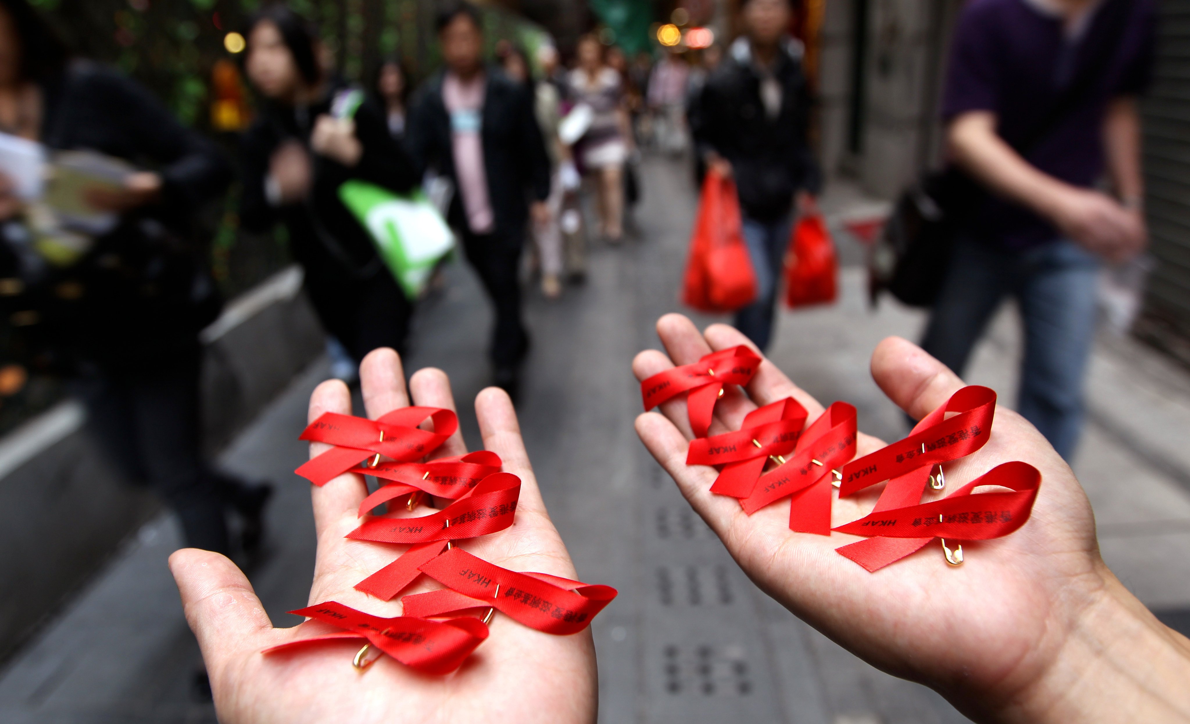 A member of the Hong Kong Aids Foundation holds red ribbons in their hands to commemorate World Aids Day, in Central, on December 1, 2010. Photo: Sam Tsang