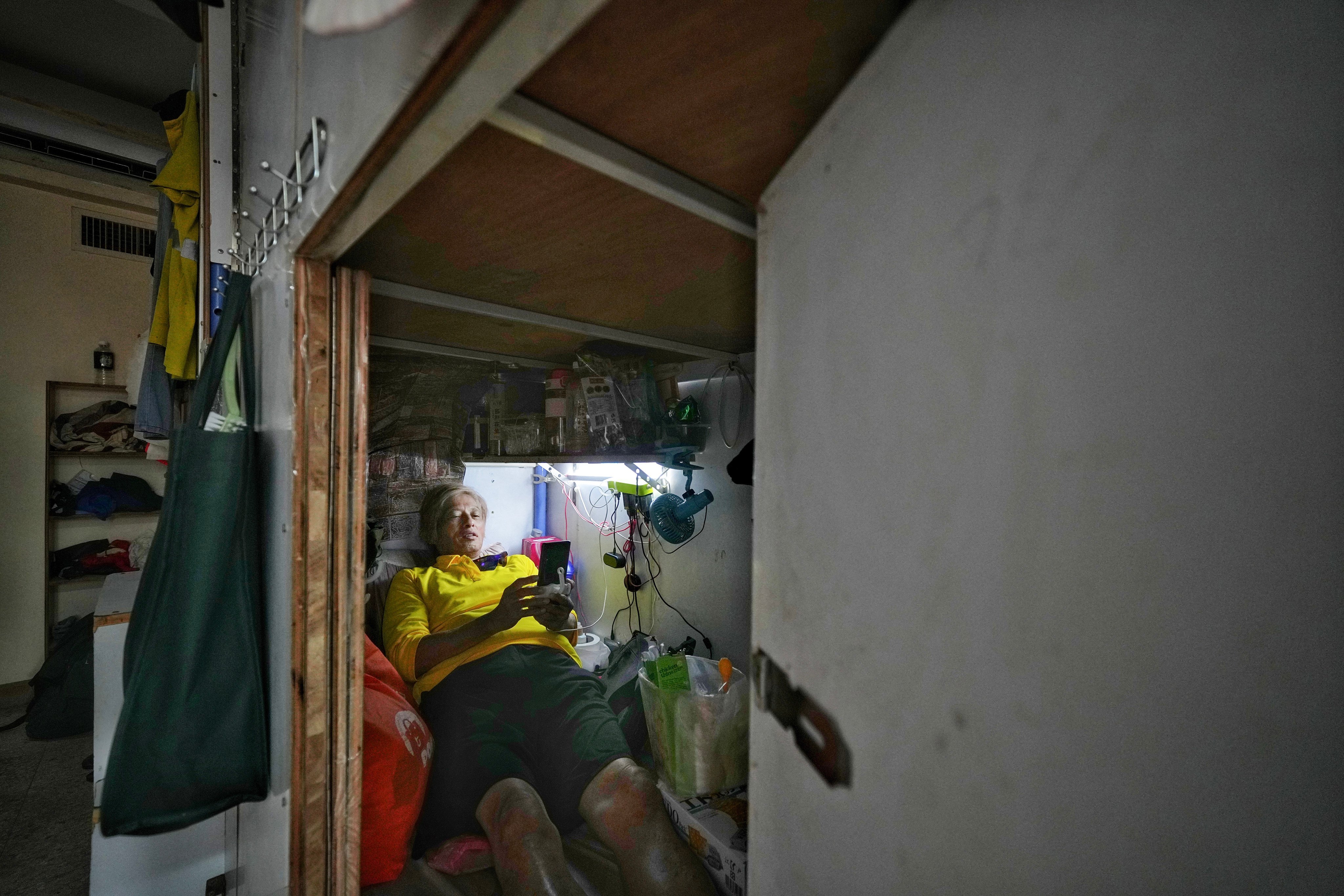 A subdivided tenant lays in his bunk bed space in Sham Shui Po. Photo: Elson Li