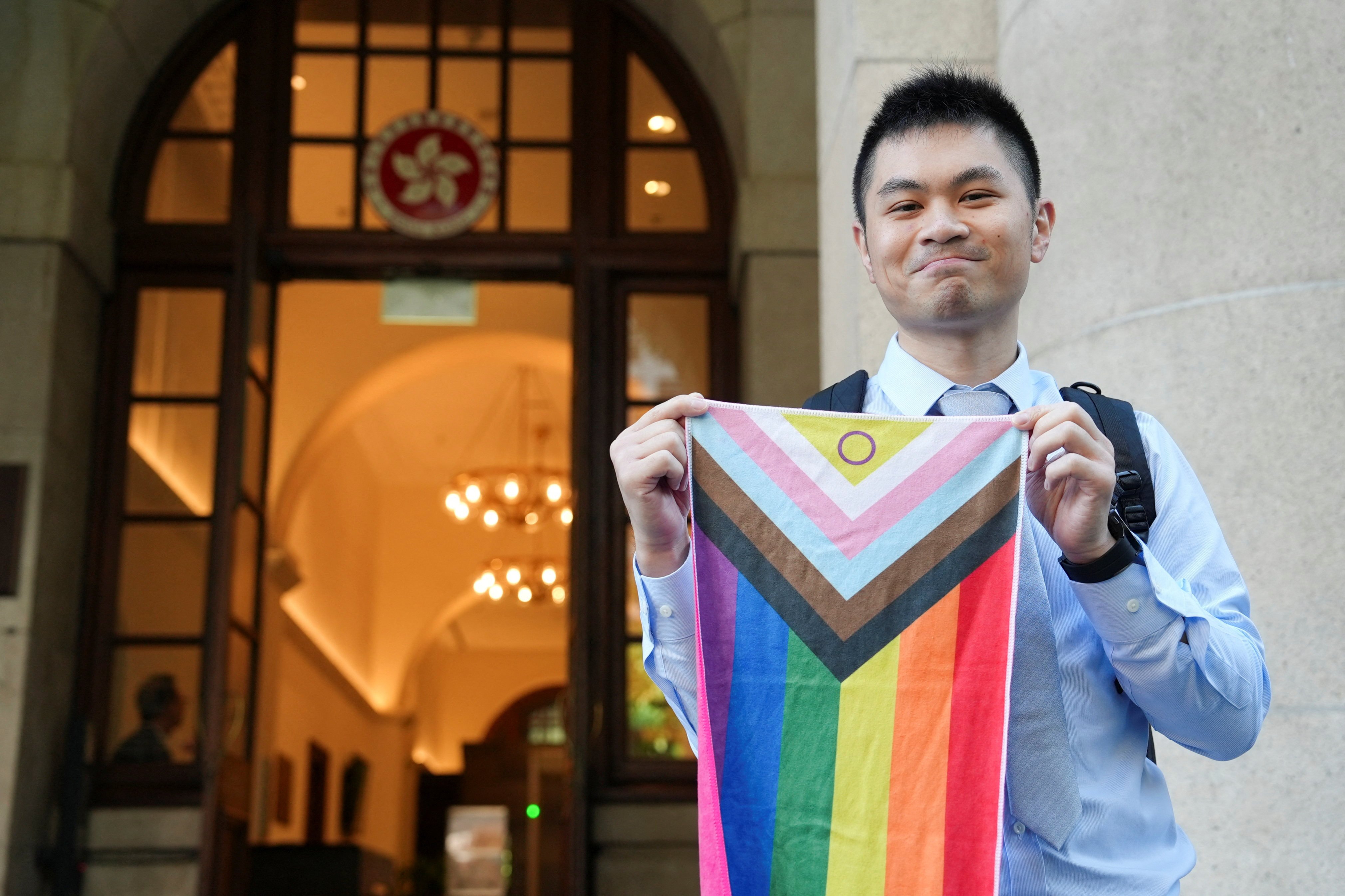 Nick Infinger, who won a years-long legal battle over the differential treatment facing same-sex couples in Hong Kong, holds up a rainbow banner after outside the city’s top court on Tuesday. Photo: Reuters