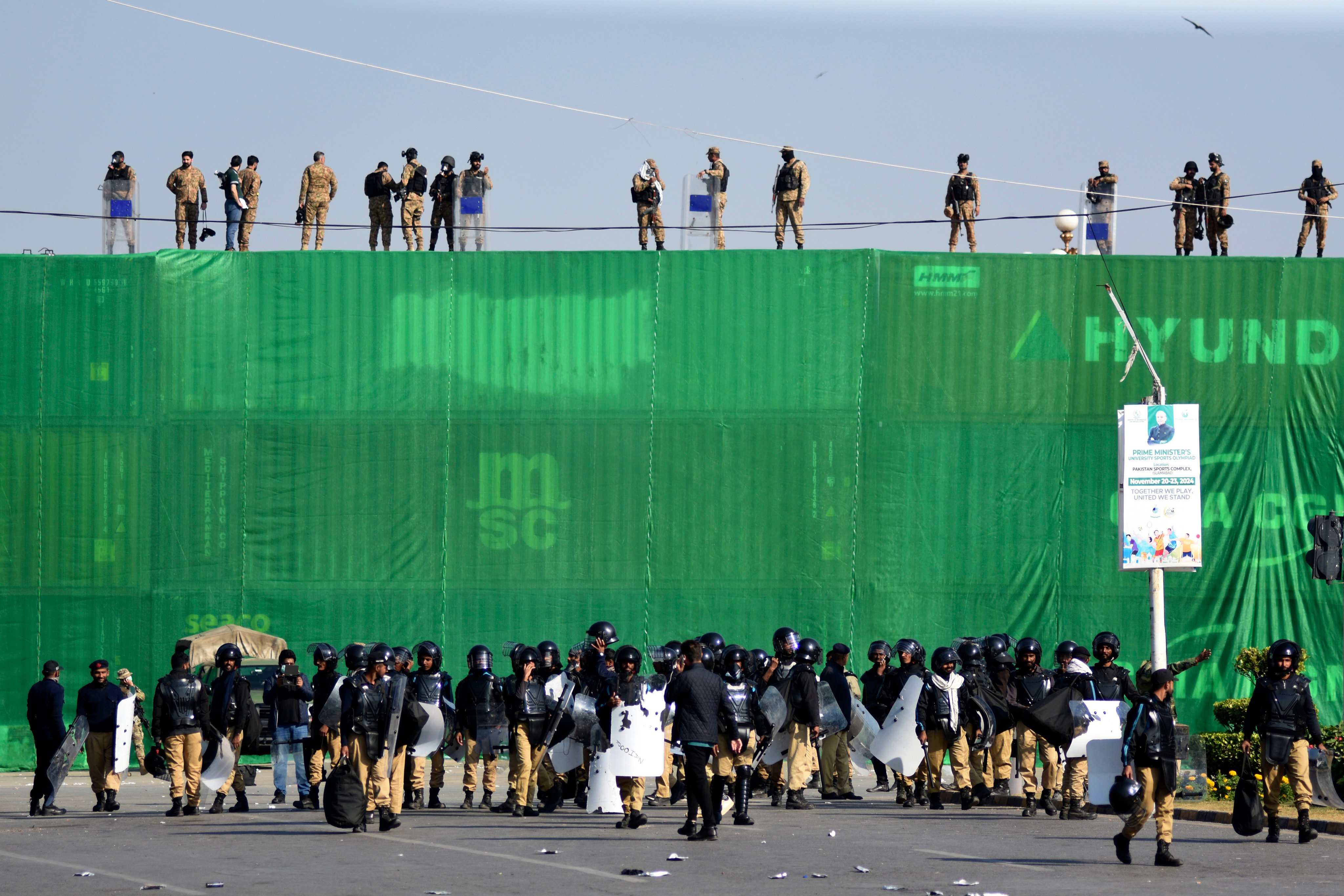 Pakistani troops and police atop a storage container barricade, ahead of a protest by supporters of imprisoned former premier Imran Khan’s Pakistan Tehreek-e-Insaf party, on Tuesday. Photo: AP