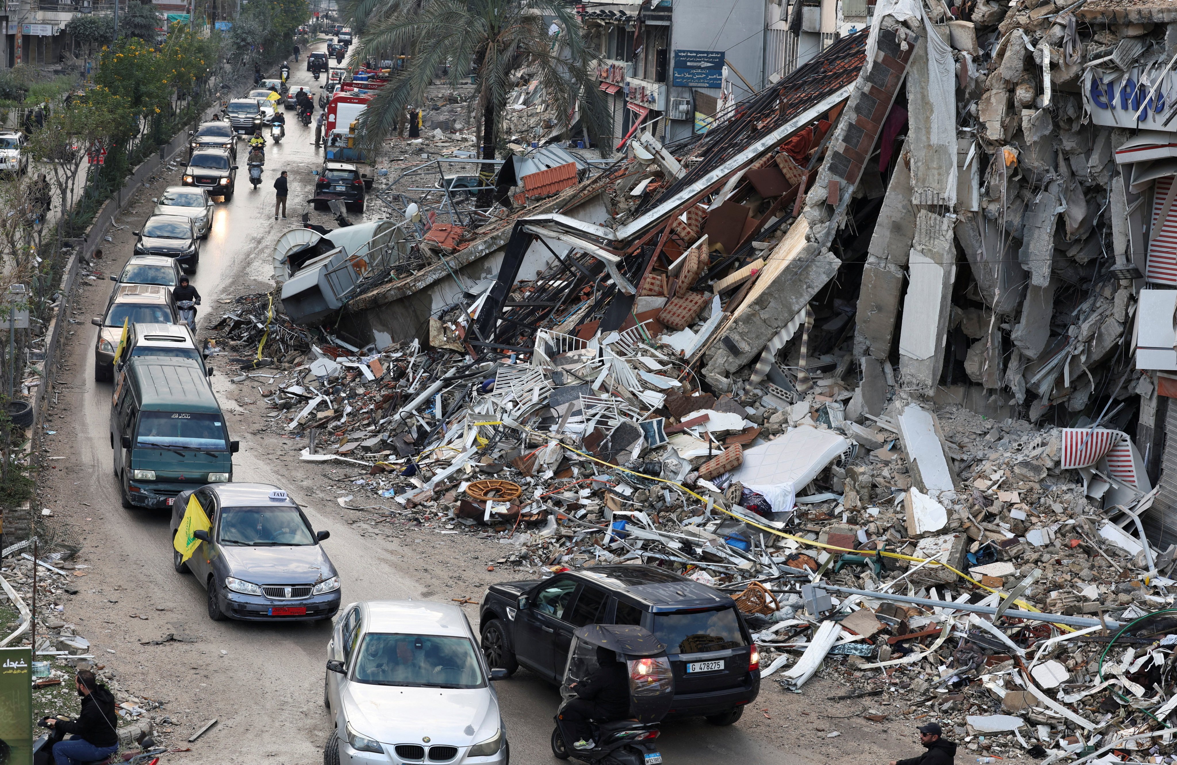 Vehicles drive near damaged buildings in Beirut’s southern suburbs, after a ceasefire between Israel and Hezbollah took effect. Photo: Reuters