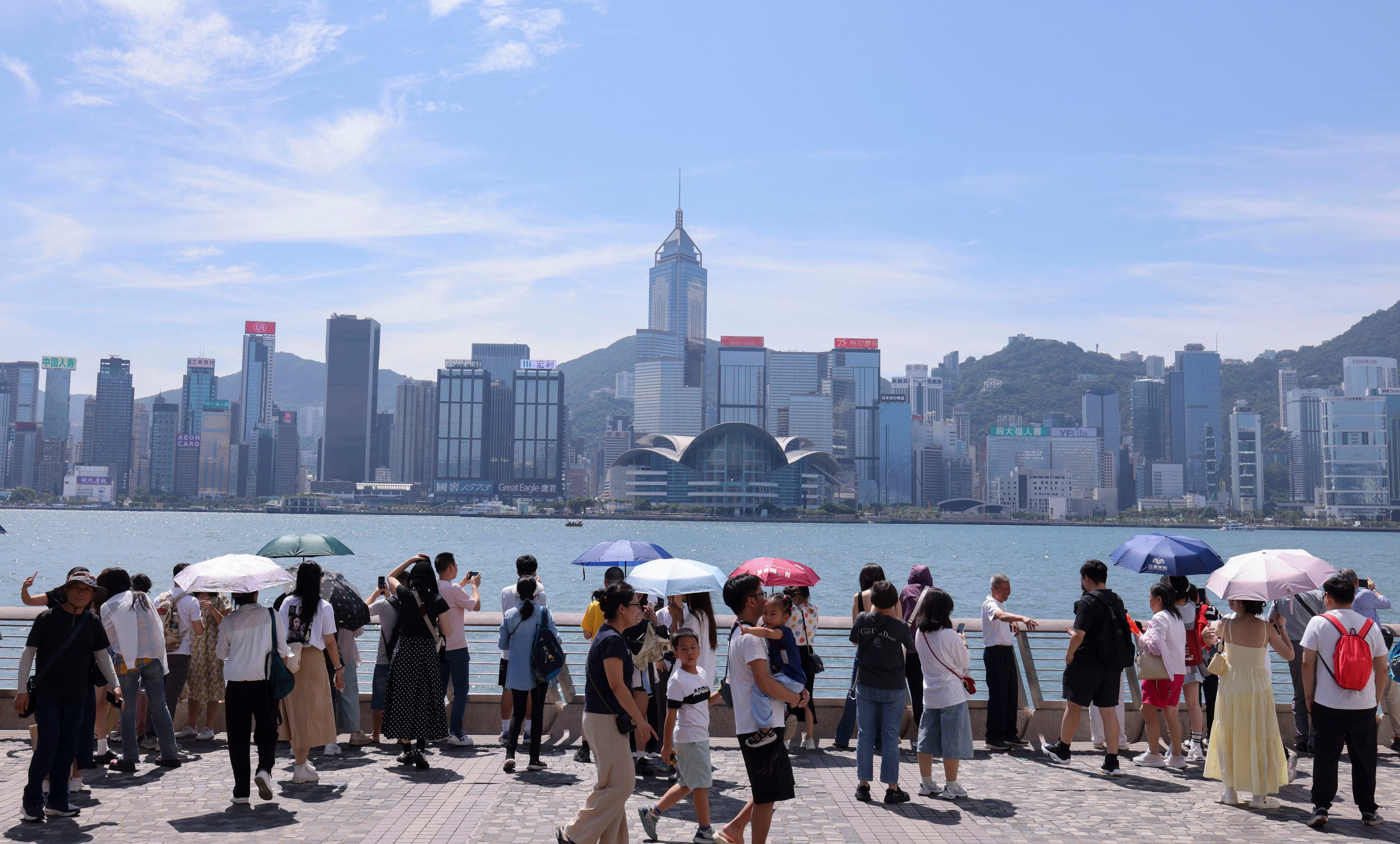 Mainland tourists enjoy the Hong Kong skyline in Tsim Sha Tsui. Photo: Nora Tam