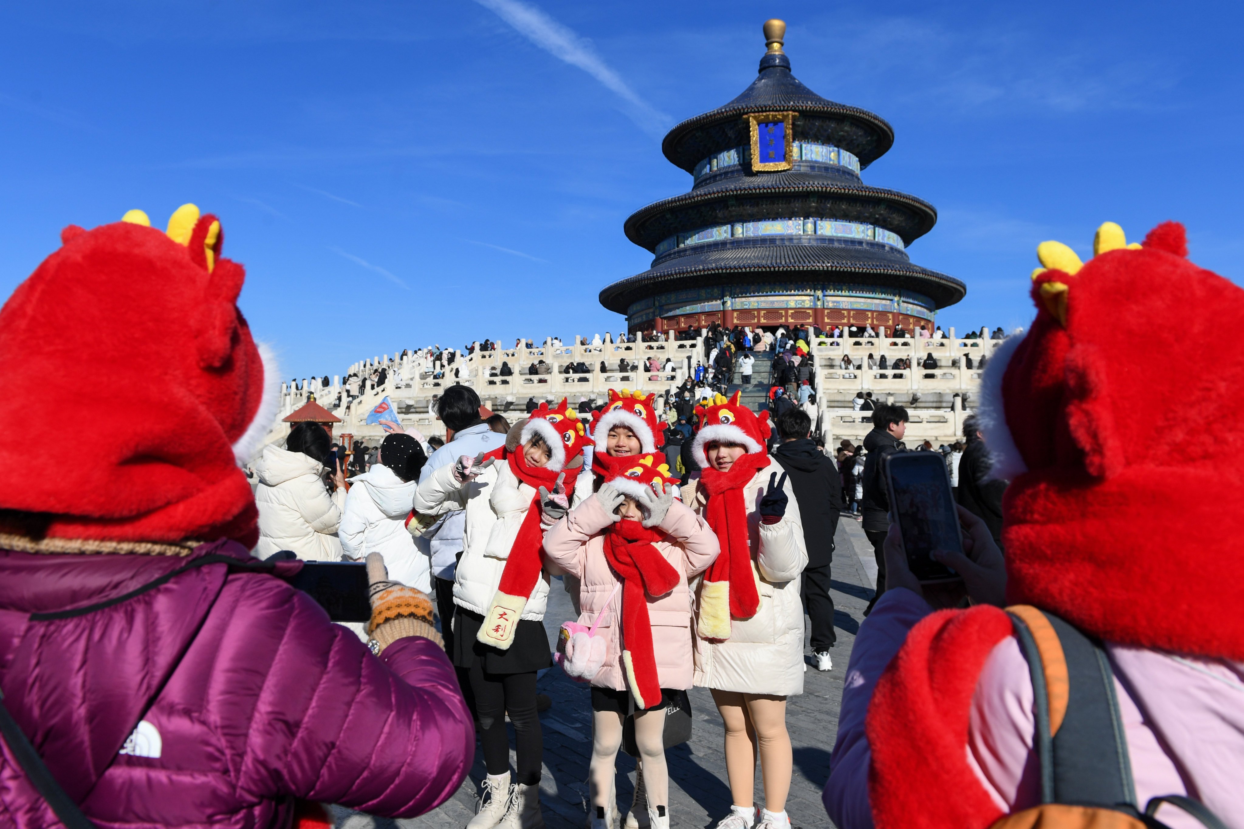 Tourists from Malaysia pose for photos wearing dragon themed hats at the Temple of Heaven in Beijing earlier this year. Photo: Xinhua