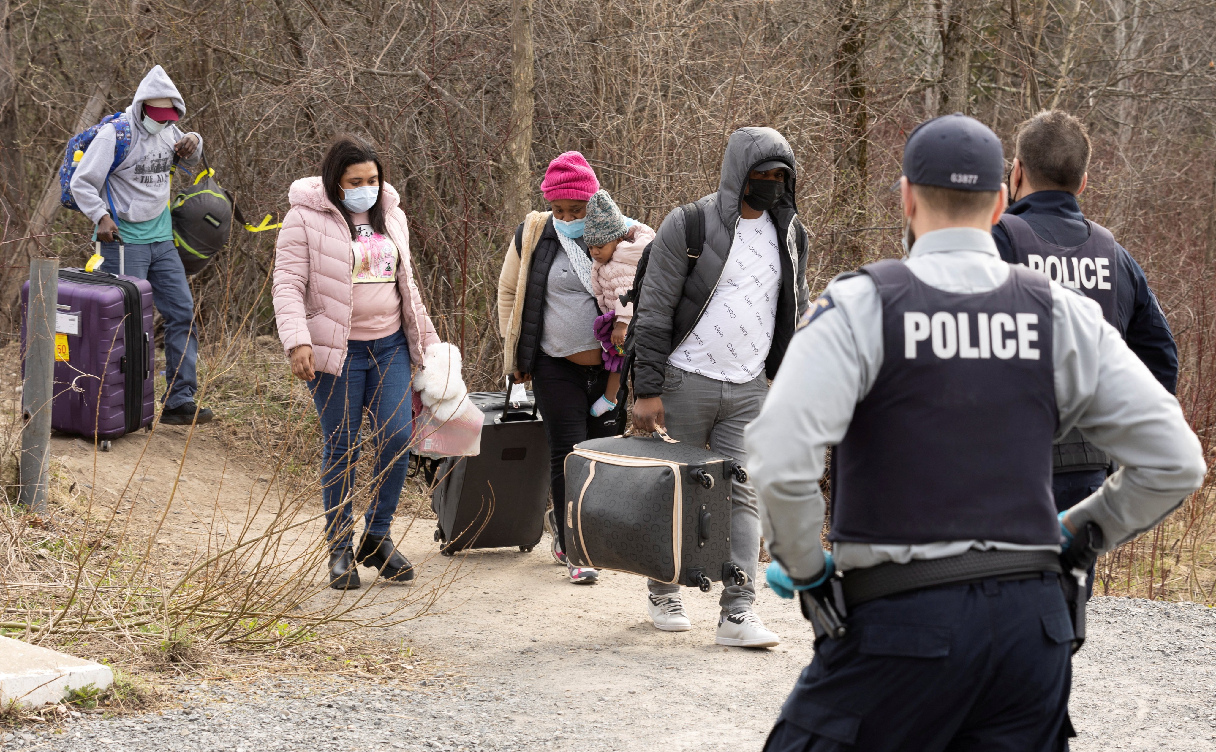 Asylum seekers cross into Canada from the US border near Hemmingford, Quebec in April 2022. Photo: Reuters