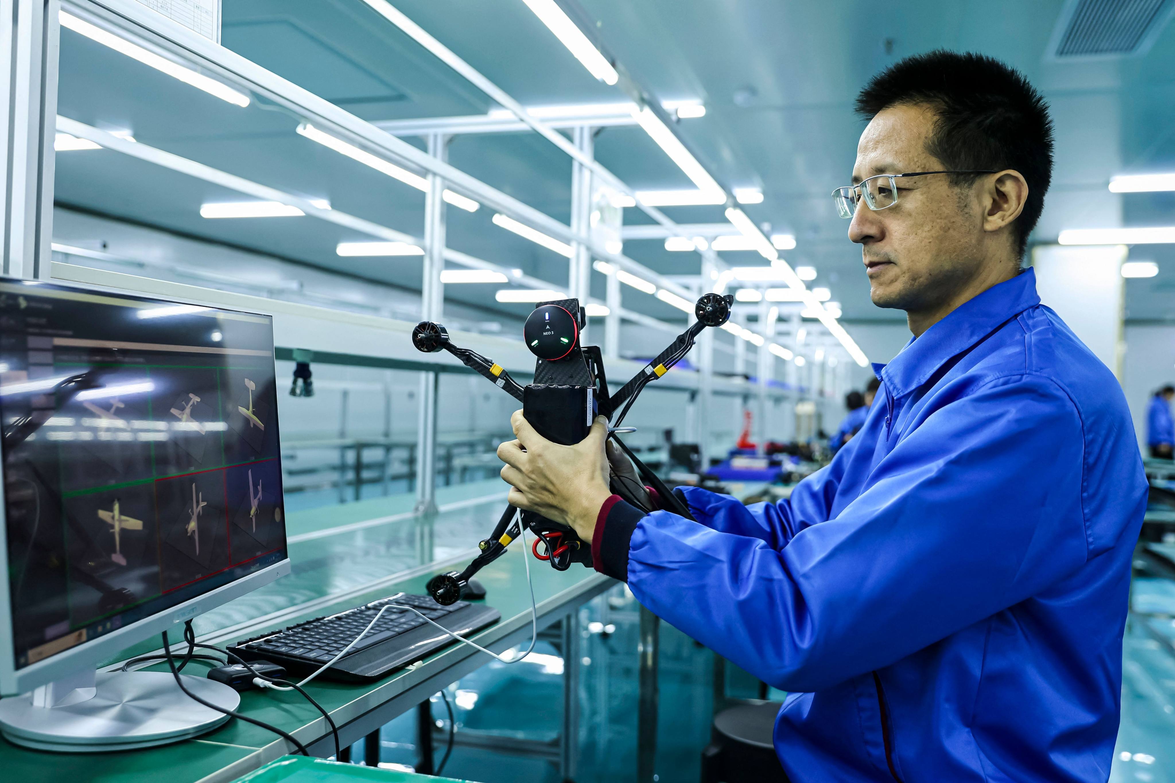 An employee works on a production line of drones. Photo: AFP