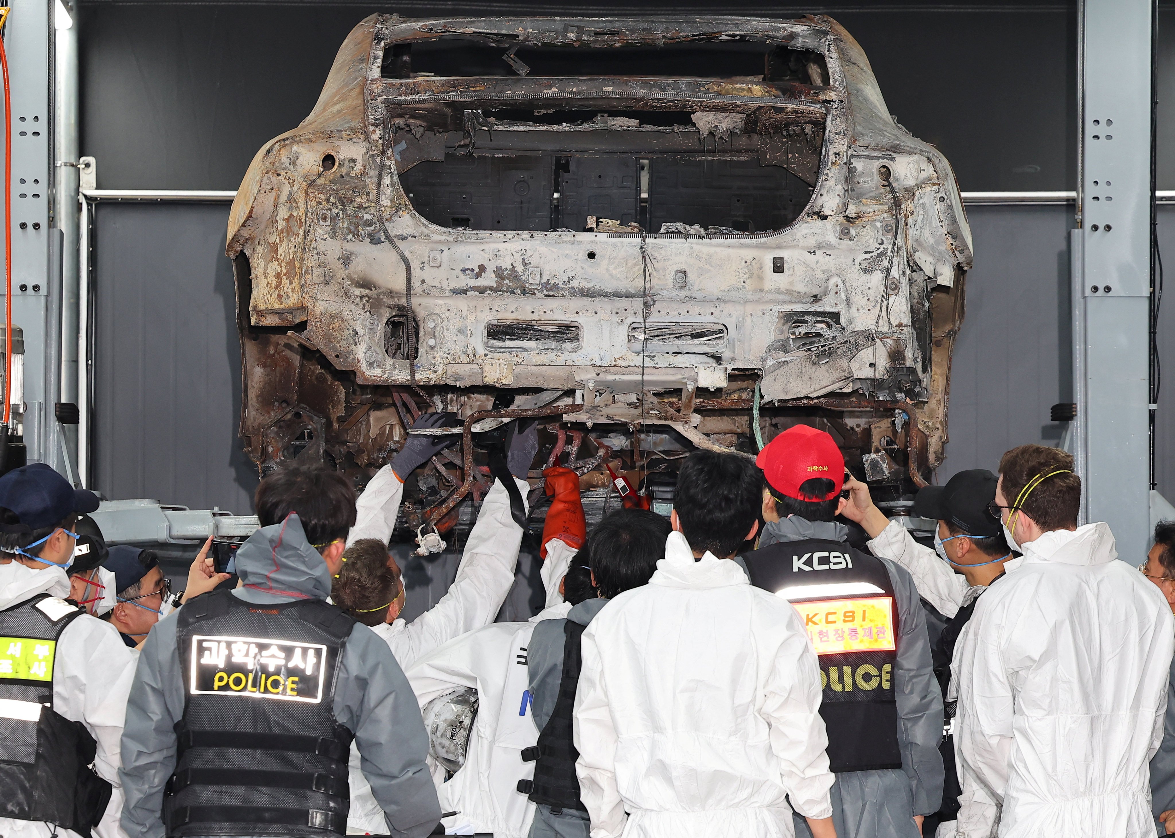 Officials conduct a forensic examination of an electric car that caught fire in an underground car park in Incheon, South Korea, in August. Photo: Yonhap via Reuters