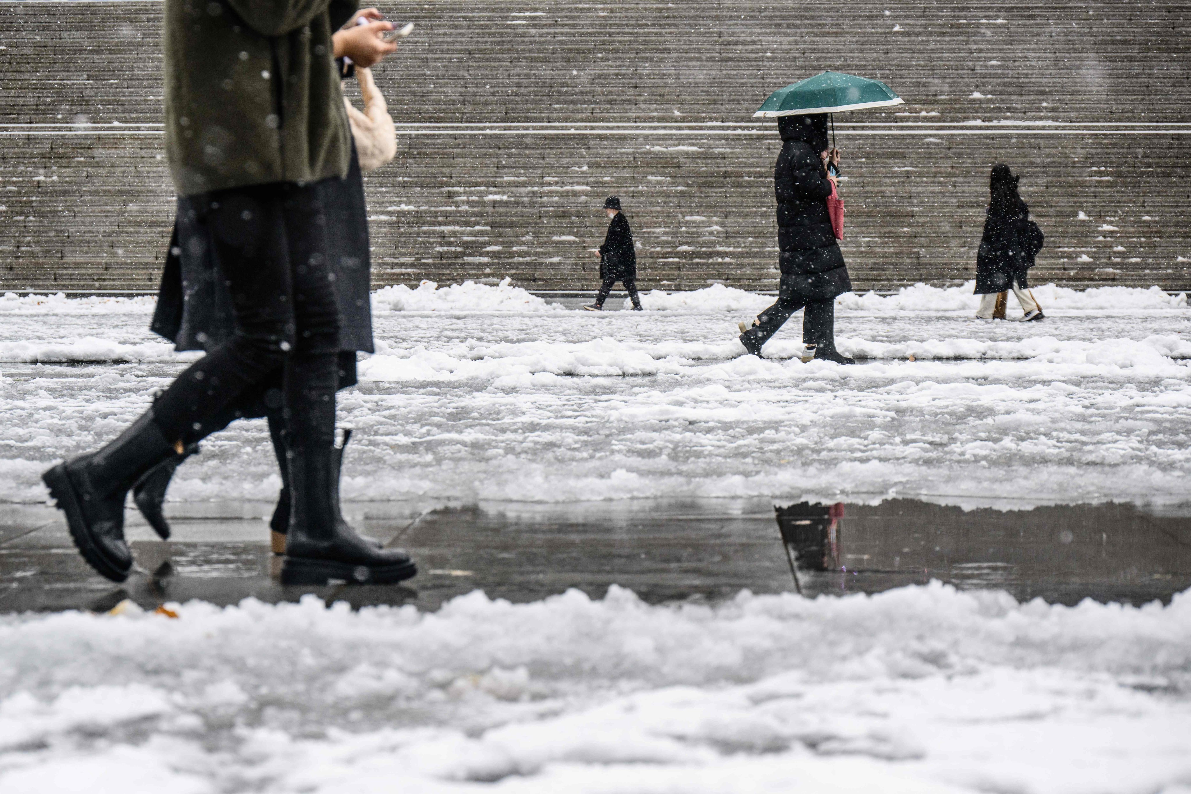 People walk amid heavy snowfall in central Seoul’s Gwanghwamun Square last month. Photo: AFP