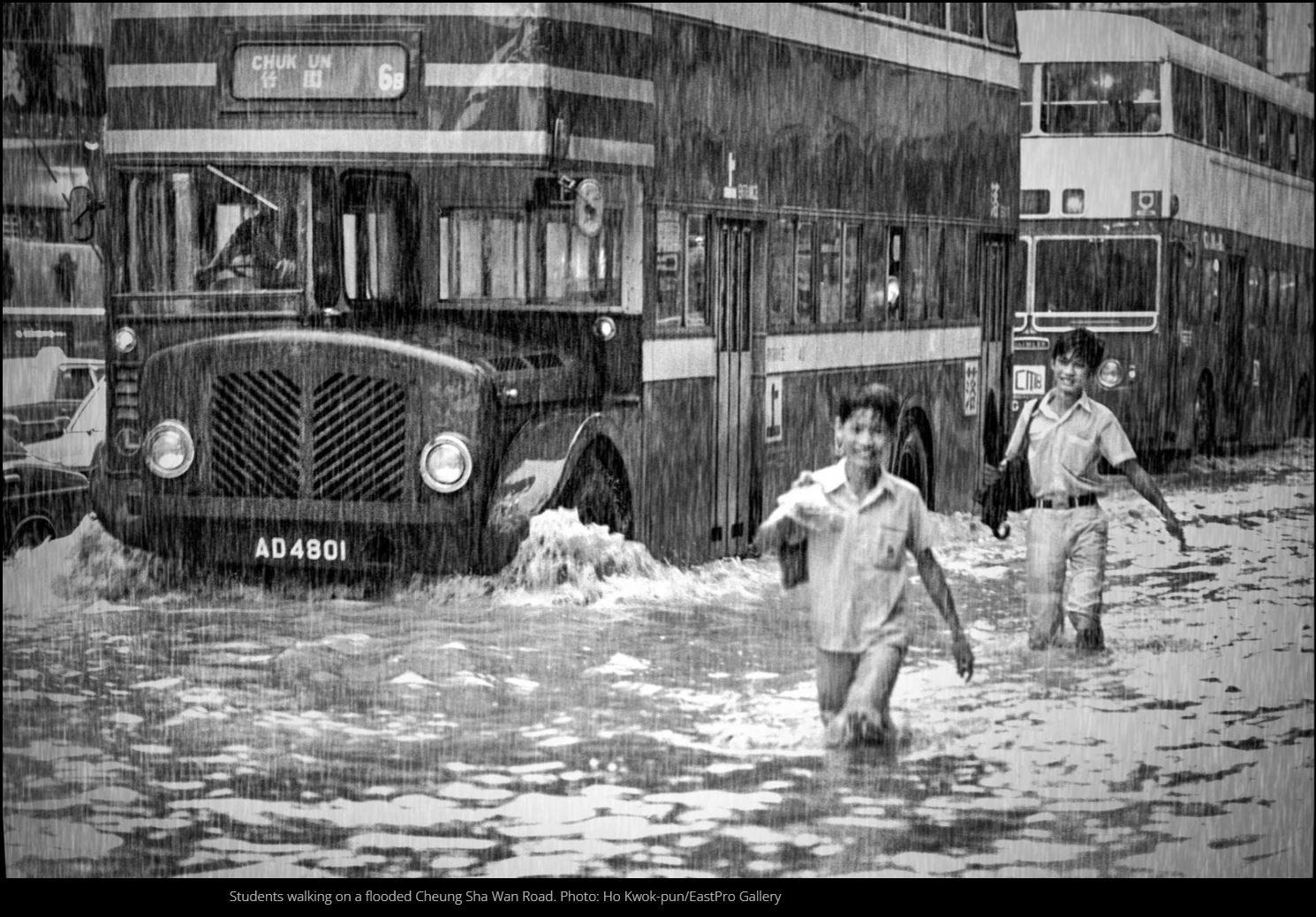 Chlidren wade through a flooded Cheung Sha Wan Road. Photo: Ho Kwok-pun/EastPro Gallery