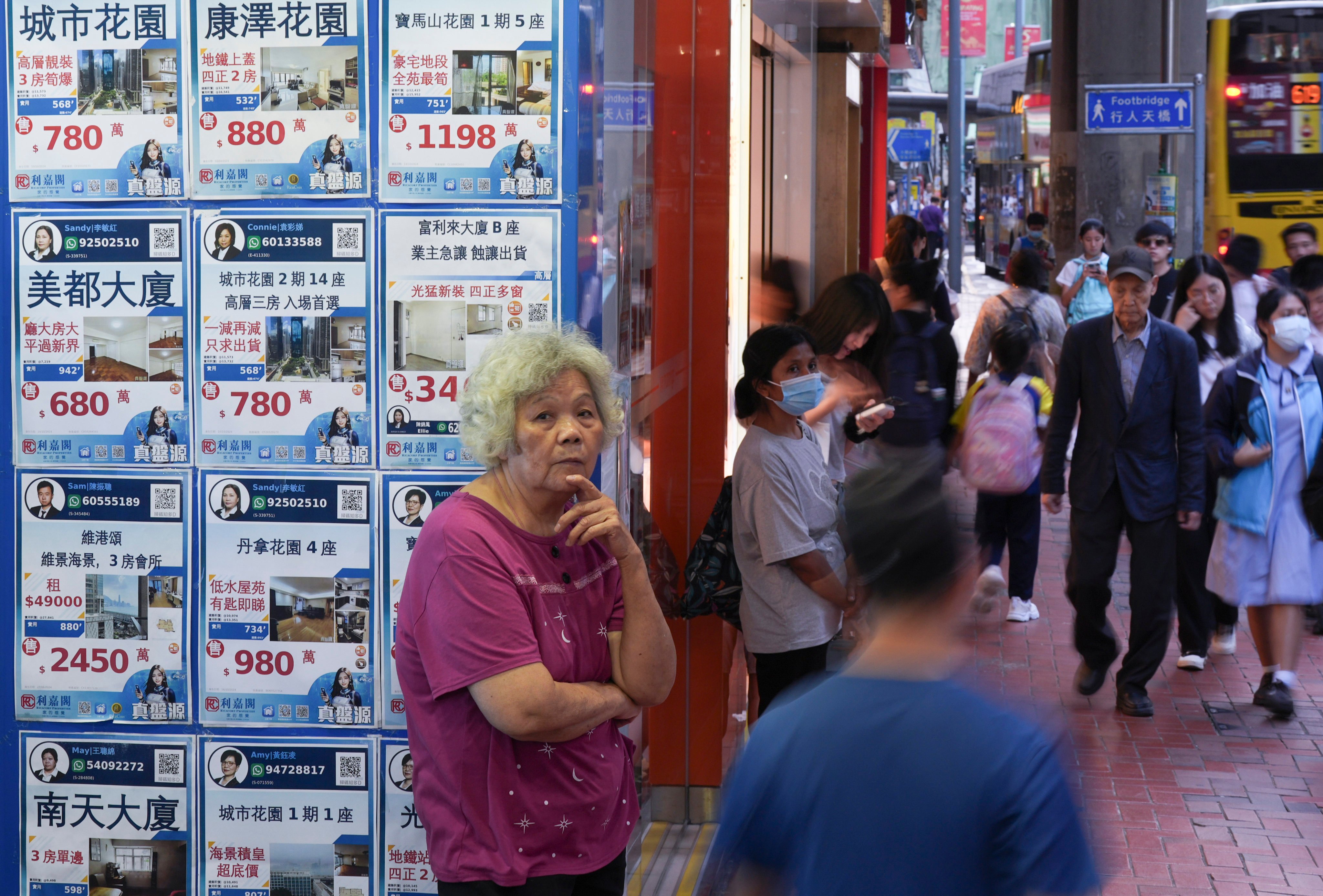 People passed a real estate agency in North Point. Photo: Eugene Lee 