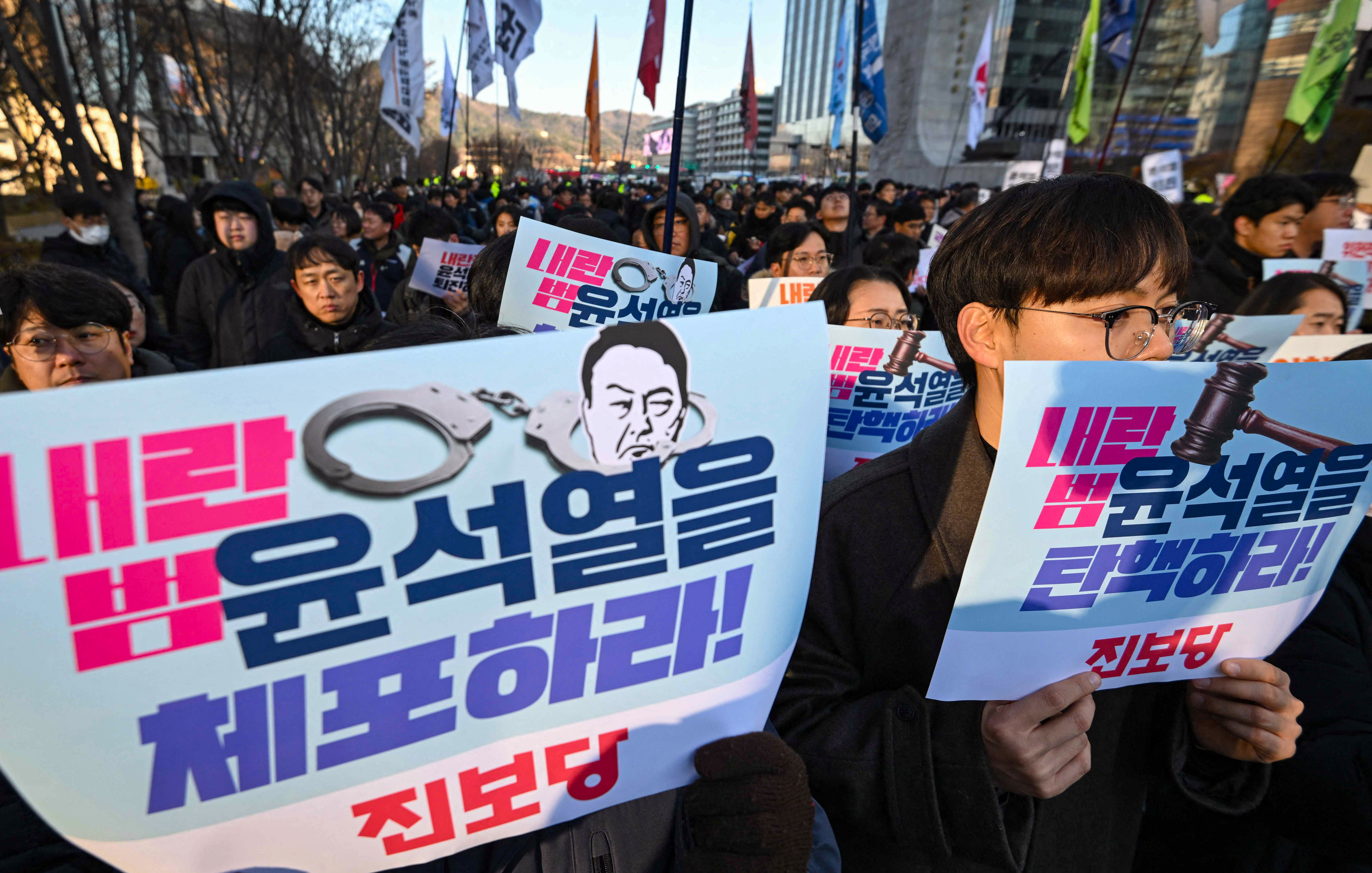 South Korean protesters hold placards reading “arrest treasonous criminal Yoon Suk-yeol!” during a rally against the president. Photo: AFP