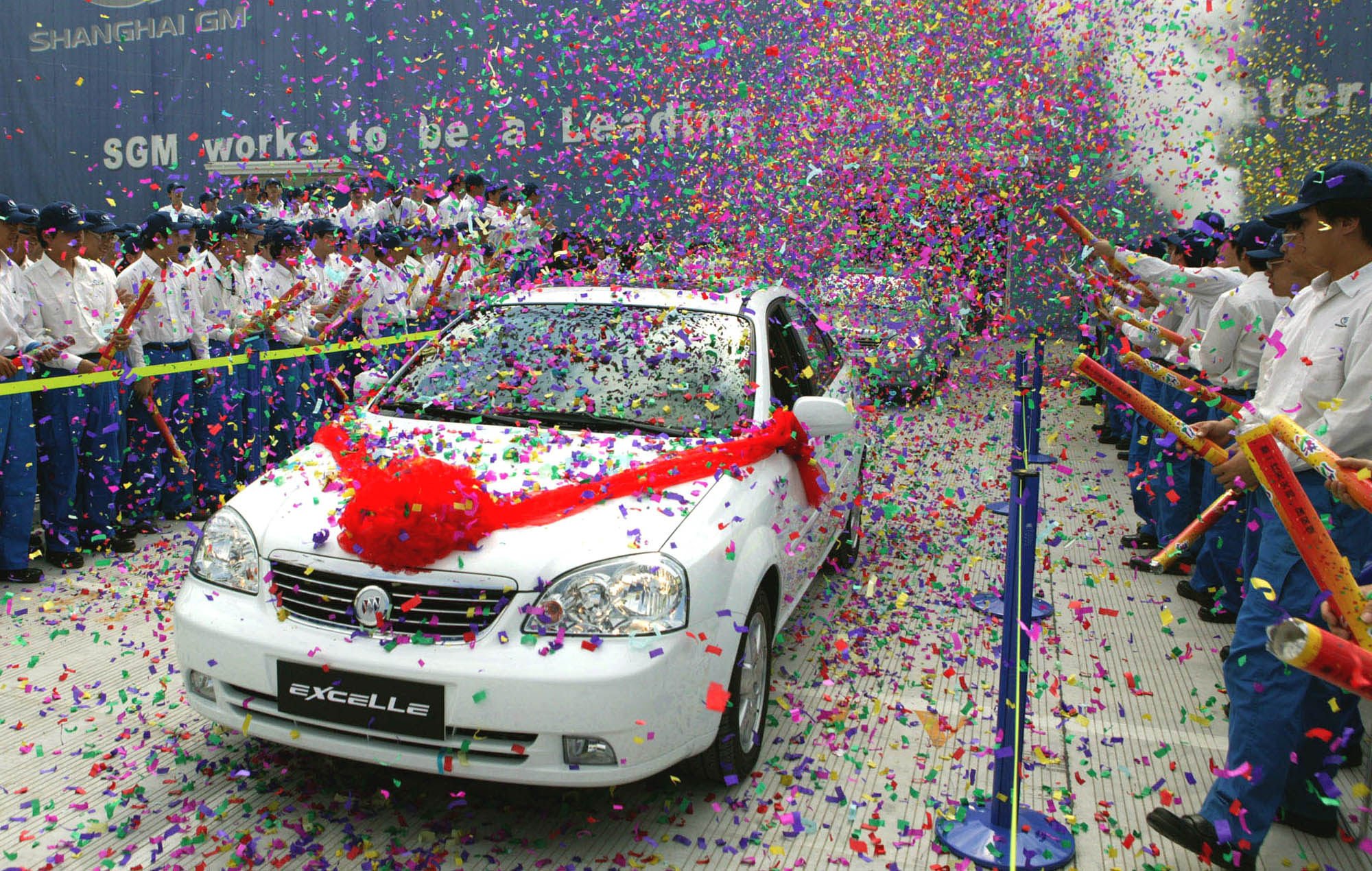 Chinese workers celebrate the first Buick Excelle sedan to roll off the production line at General Motor’s new facility in eastern Shanghai’s Pudong district, in May 2005. Photo: AP Photo