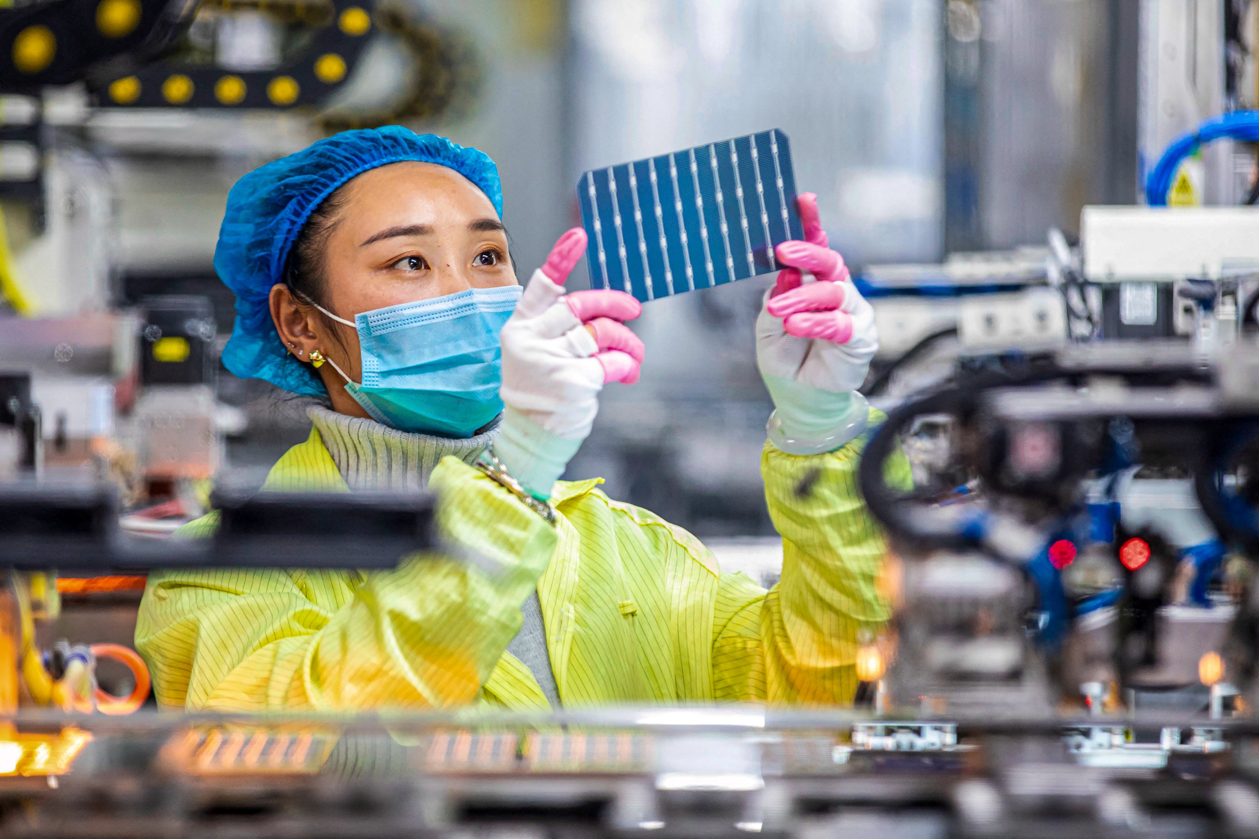 A worker checks solar photovoltaic modules used in solar panels at a factory in Haian in eastern Jiangsu province. Photo: AFP