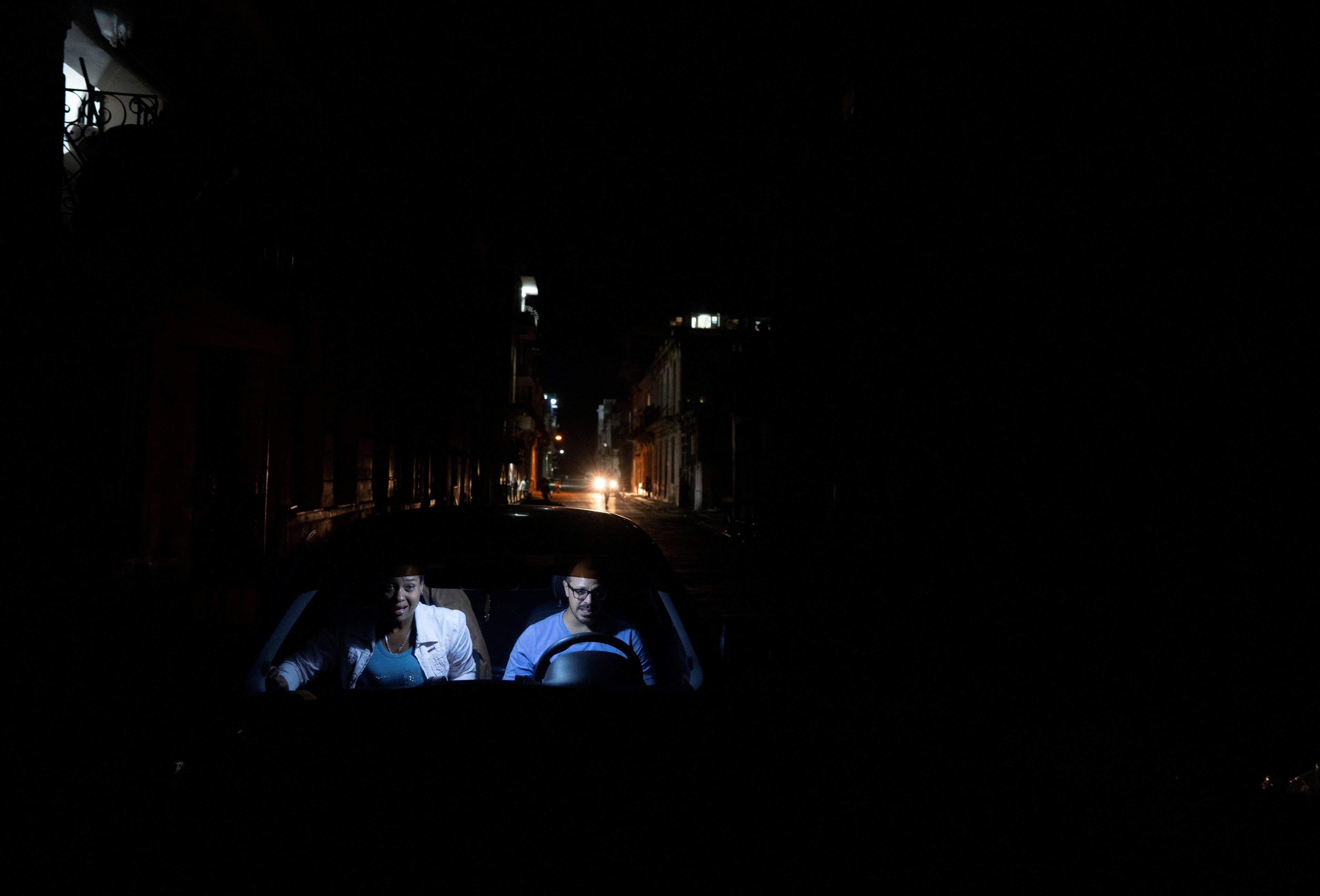 A couple inside a car during an electrical grid collapse, in Havana, Cuba. Photo: Reuters