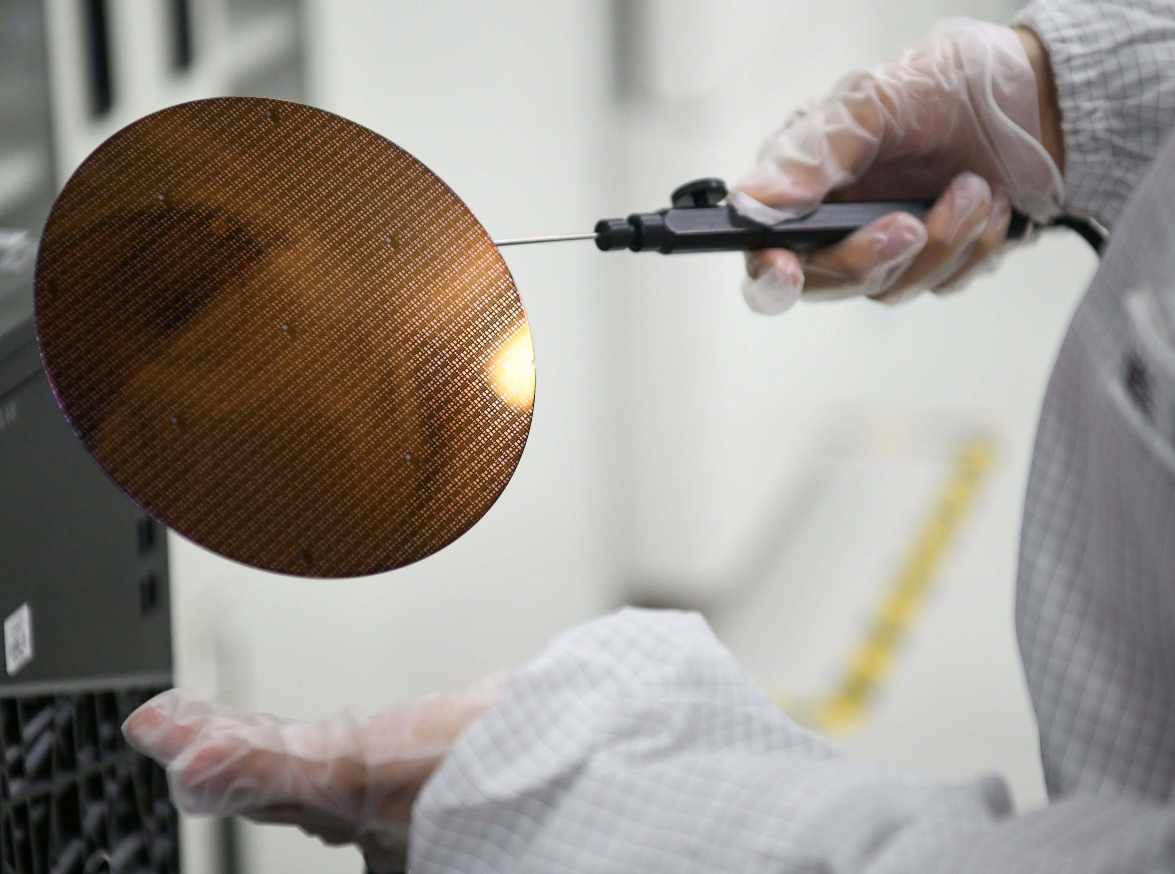 A researcher displays a wafer at Shaanxi Institute of Advanced OEIC Technologies, in Xi’an on March 4, 2024. Photo: Xinhua