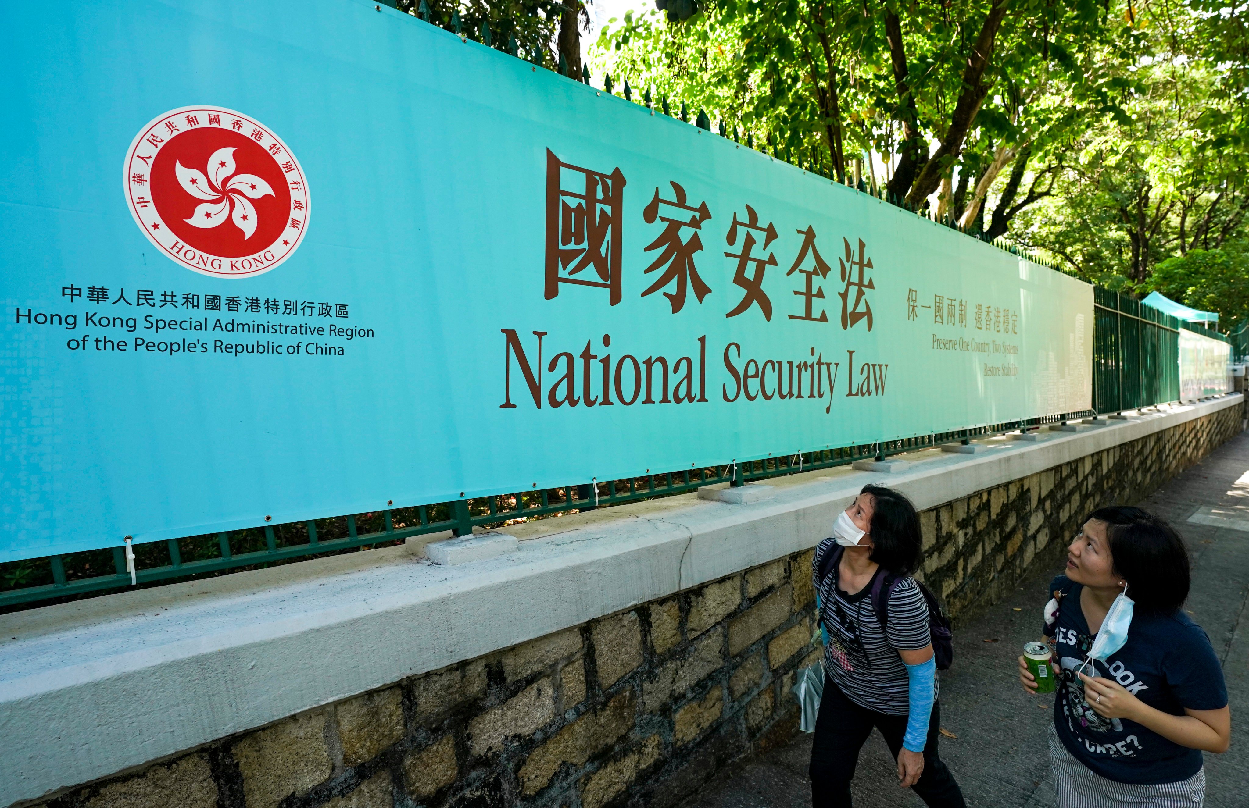 Two women look at a banner publicising the national security law on Albany Road, Central. Photo: Felix Wong