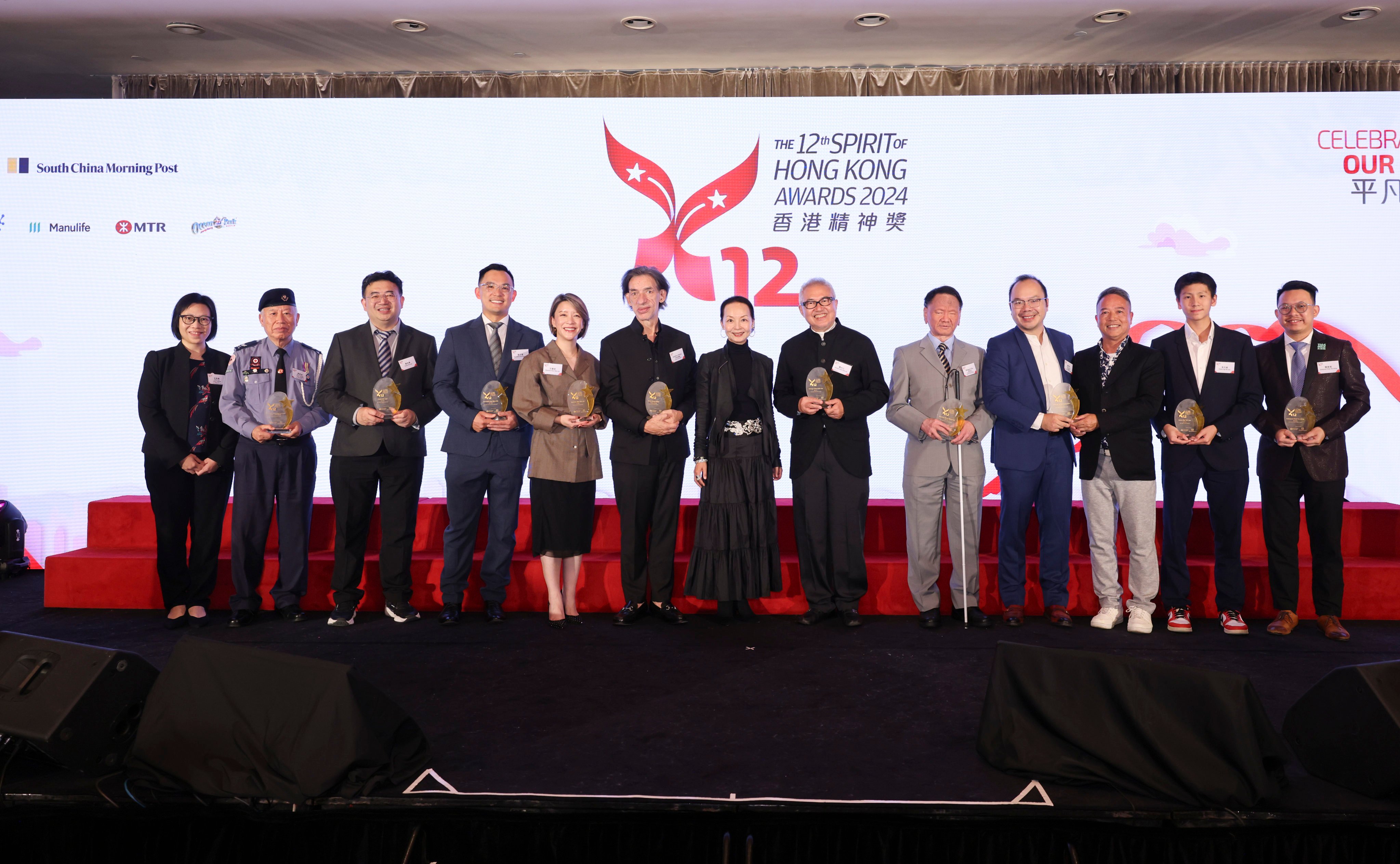 (L-R) The Spirit of Teamwork Award winners Irene Lui and Hero Leung, representing the Elderly Unit of the Hong Kong Red Cross; The Spirit of Nurturing Award winner Chuin Chi-wai; The Spirit of Entrepreneurship Award winner Kenneth Choi Man-kin; The Spirit of Community Award winner Queenie Man; The Spirit of Culture Award winners Septime Webre and Linda Fung, representing the Hong Kong Ballet; The Spirit of Innovation Award winner George Chen Dah-ren; The Spirit of Perseverance Award winner Jennifer Wong Ming-wai, represented by Dr Welgent Chu; The Spirit of Sustainability Award winner Willy Kwong, presenting A Plastic Ocean Foundation; The Spirit of Youth Award winner Owen Ng Yat-san; and Lion Rock People’s Choice Award winner Edmund Chan pose for group photo at the 12th Spirit of Hong Kong Awards 2024. Photo: Nora Tam