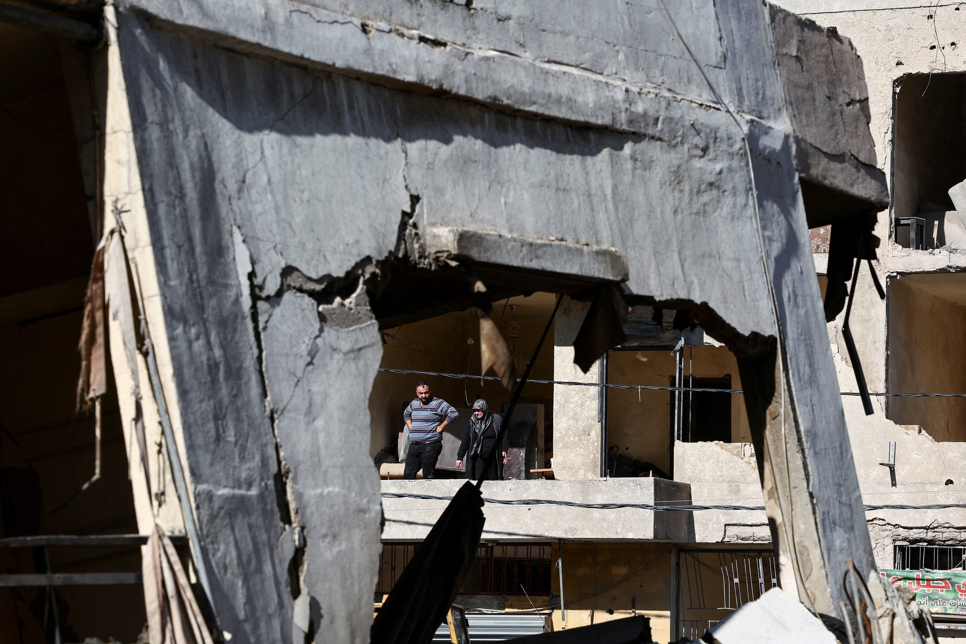 A man and a woman look out from a damaged building in the Chiyah district of Beirut’s southern suburbs. Photo: Reuters