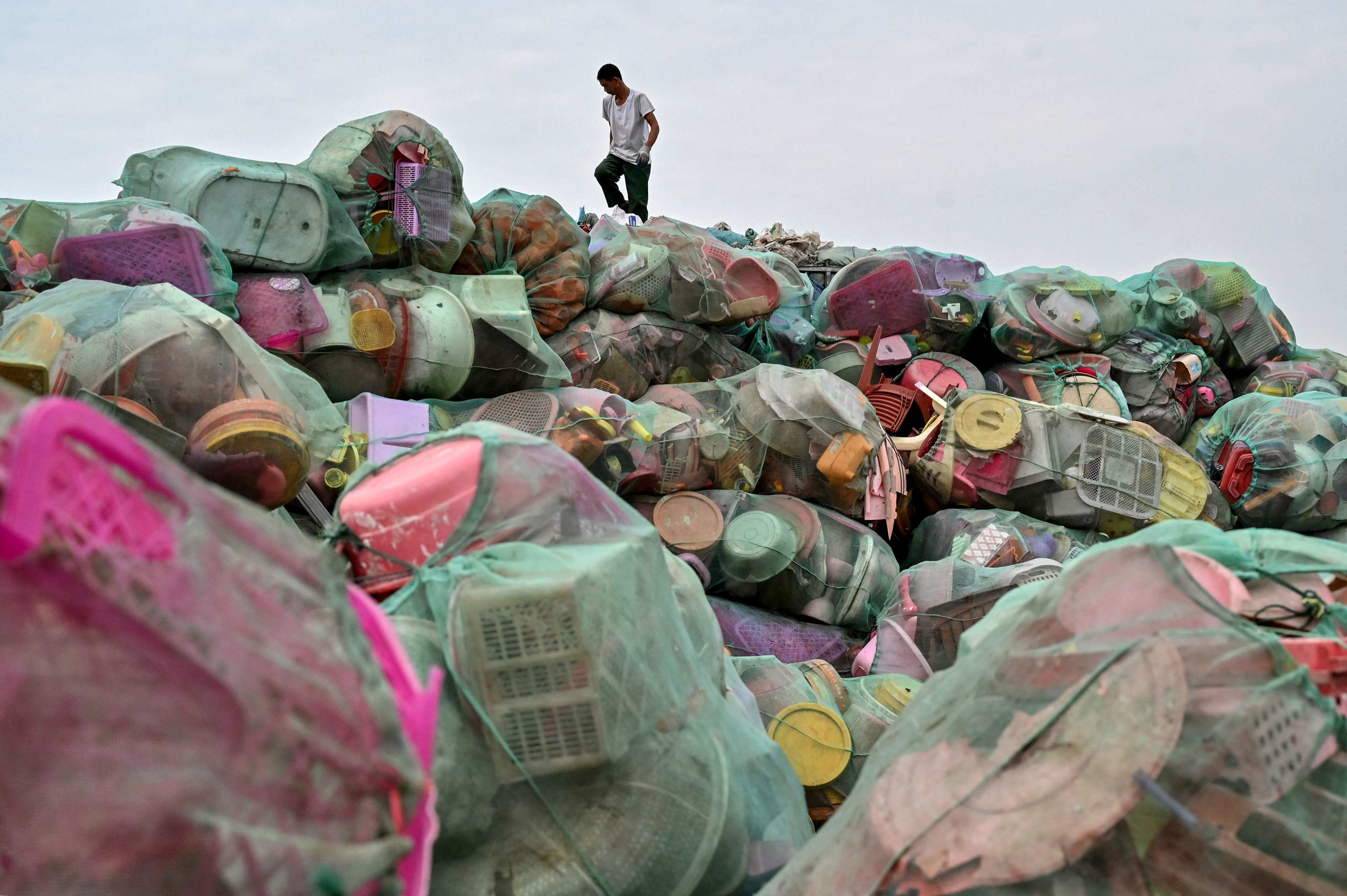 A man walks next to bags of plastic waste at a recycling site near Hanoi, Vietnam, on September 17. Photo: AFP