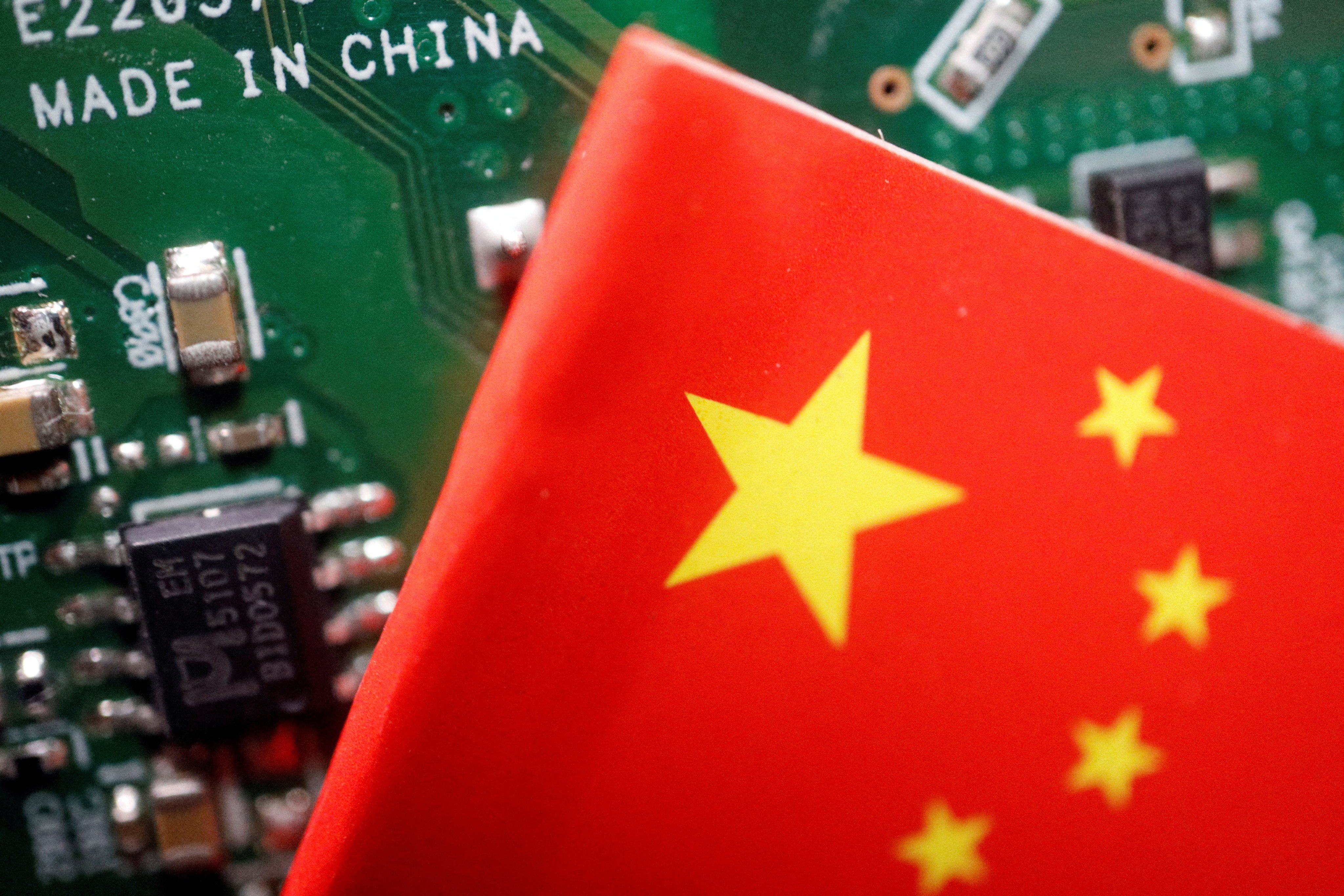 A Chinese flag is displayed next to a ‘Made in China’ sign on a printed circuit board, in this illustration picture taken February 17, 2023. Photo: Reuters