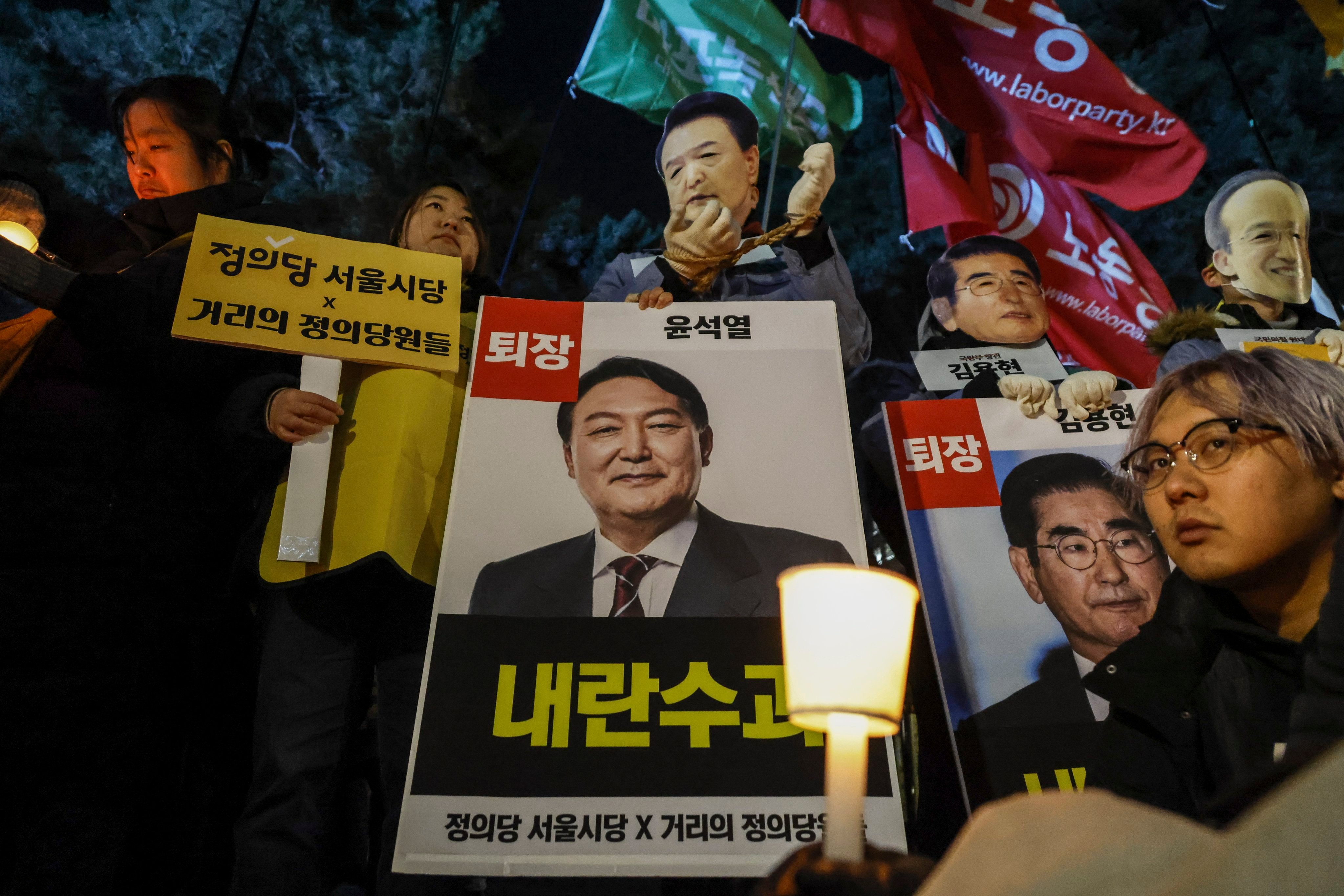 Protesters hold candles and placards calling for the arrest of President Yoon Suk Yeol and his wife Kim Keon hee, during a rally outside the National Assembly in Seoul on Friday. Photo: EPA-EFE