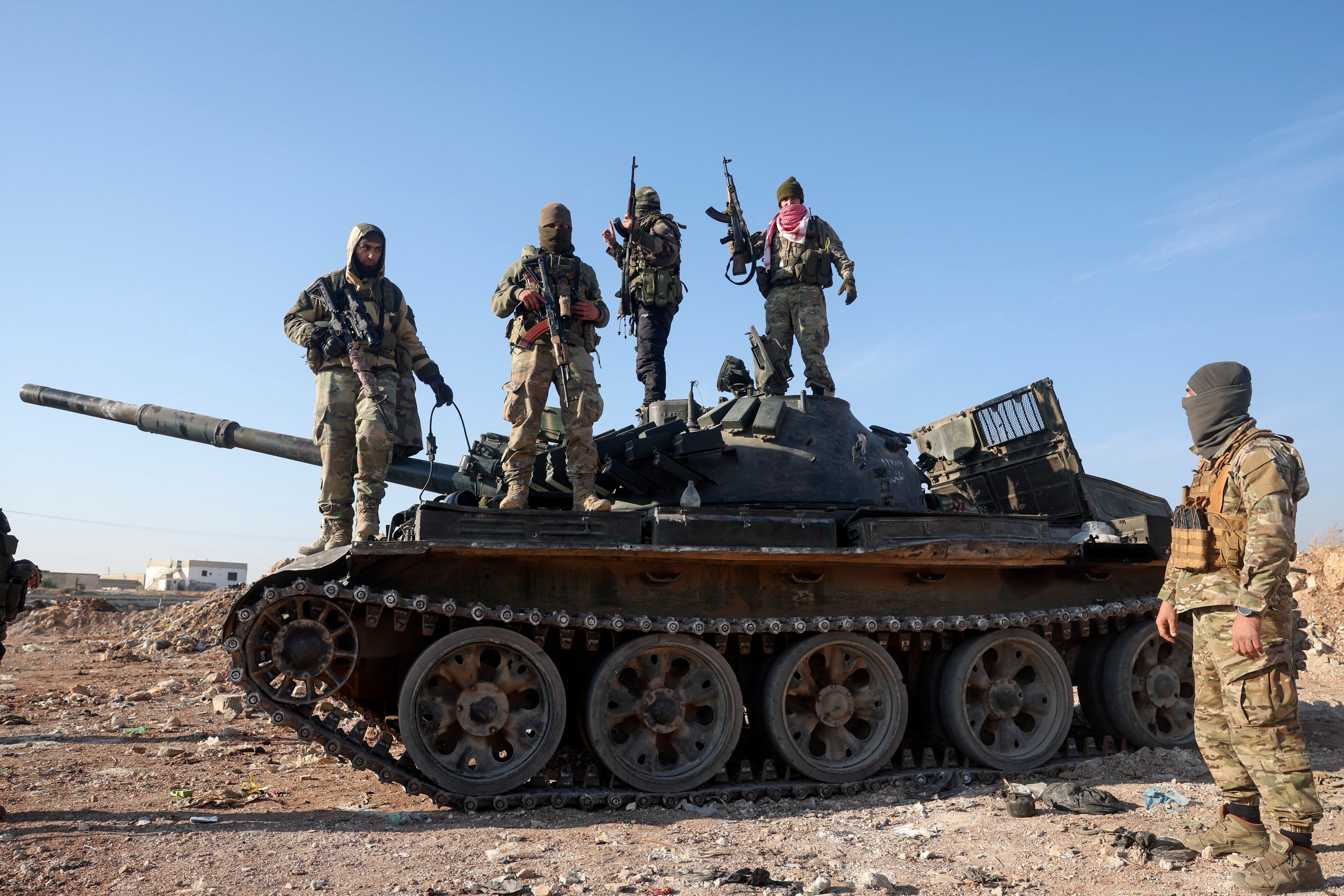 Syrian opposition fighters stand atop a seized military vehicle on the outskirts of Hama on Tuesday. Photo: AP