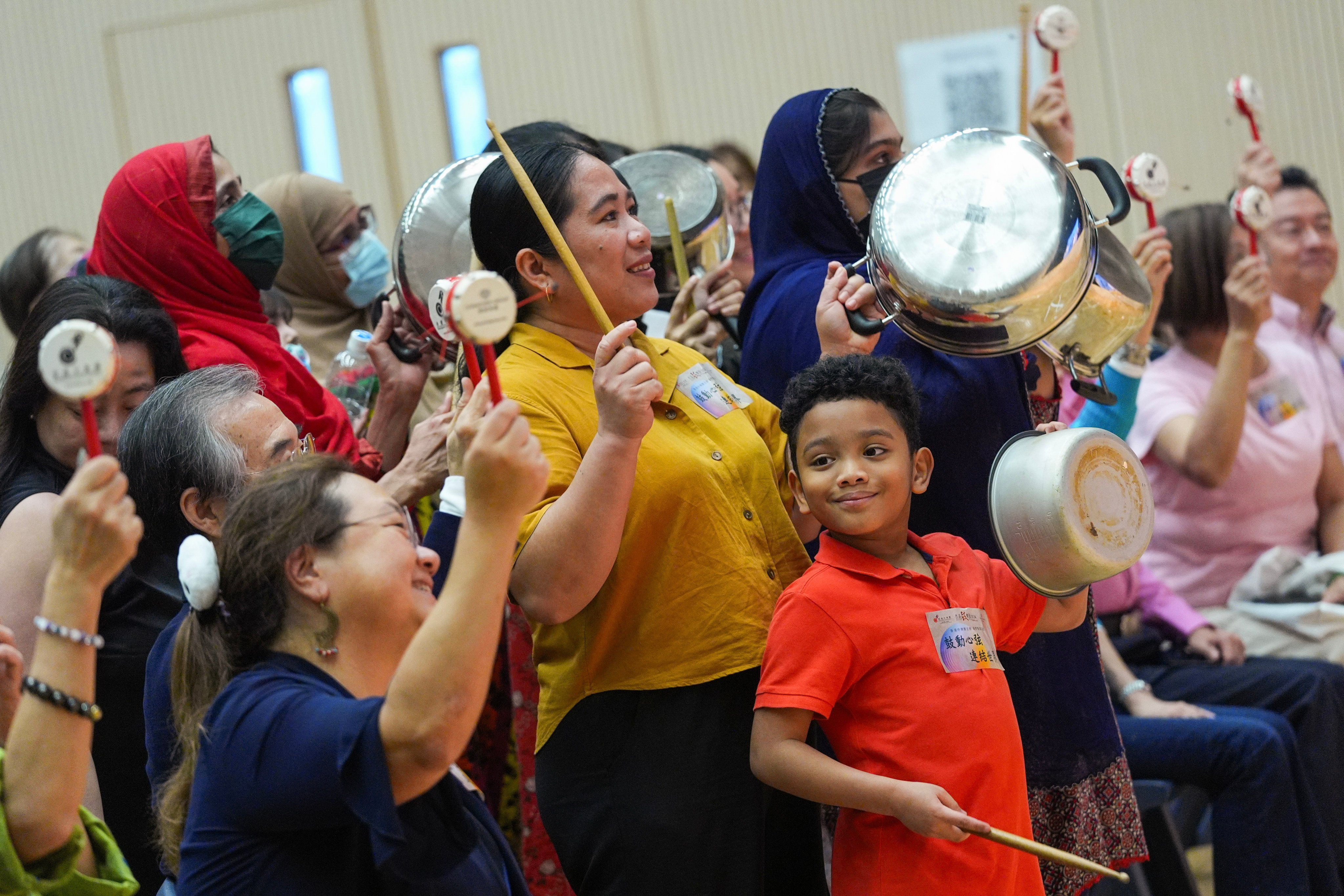 Emily Cablas Anane (centre) and her son Daniel (second from front right) play the drums on cooking pots and eco-friendly instruments at a festival workshop. Photo: Eugene Lee