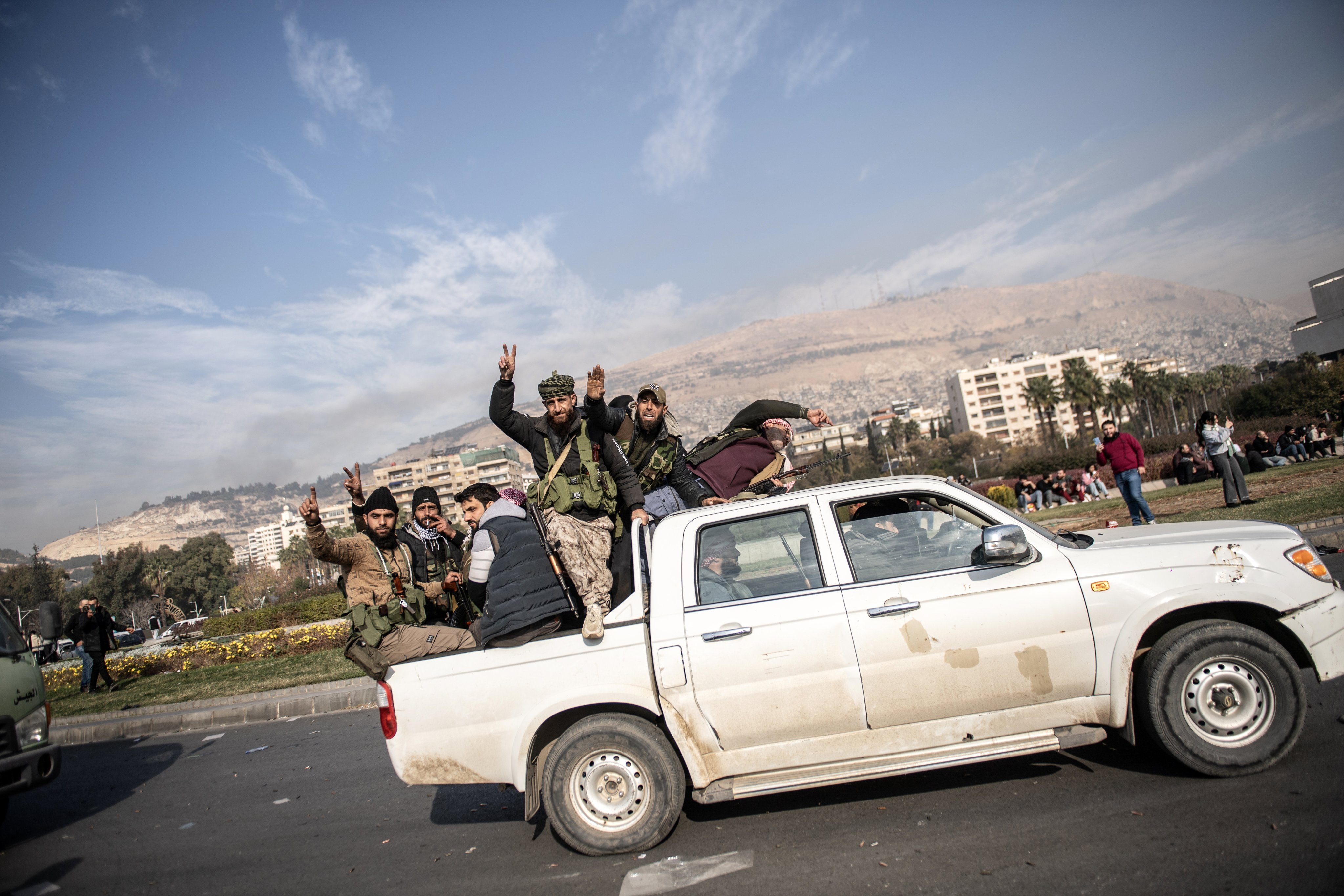 Rebels riding on the back of a vehicle celebrate after Syrian rebels captured the city of Damascus on Sunday. Photo: EPA-EFE