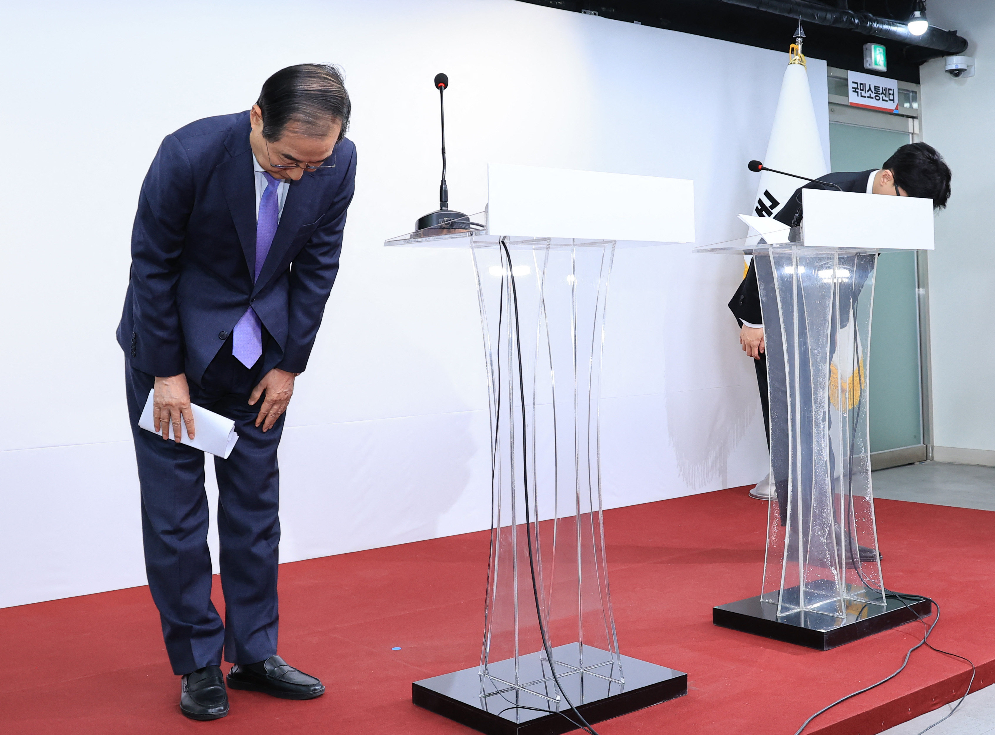 South Korea’s Prime Minister Han Duck-soo (left) and the ruling People Power Party leader Han Dong-hoon (right) bow during a press conference after their meeting to discuss plans for President Yoonl’s “orderly retreat”. Photo: AFP