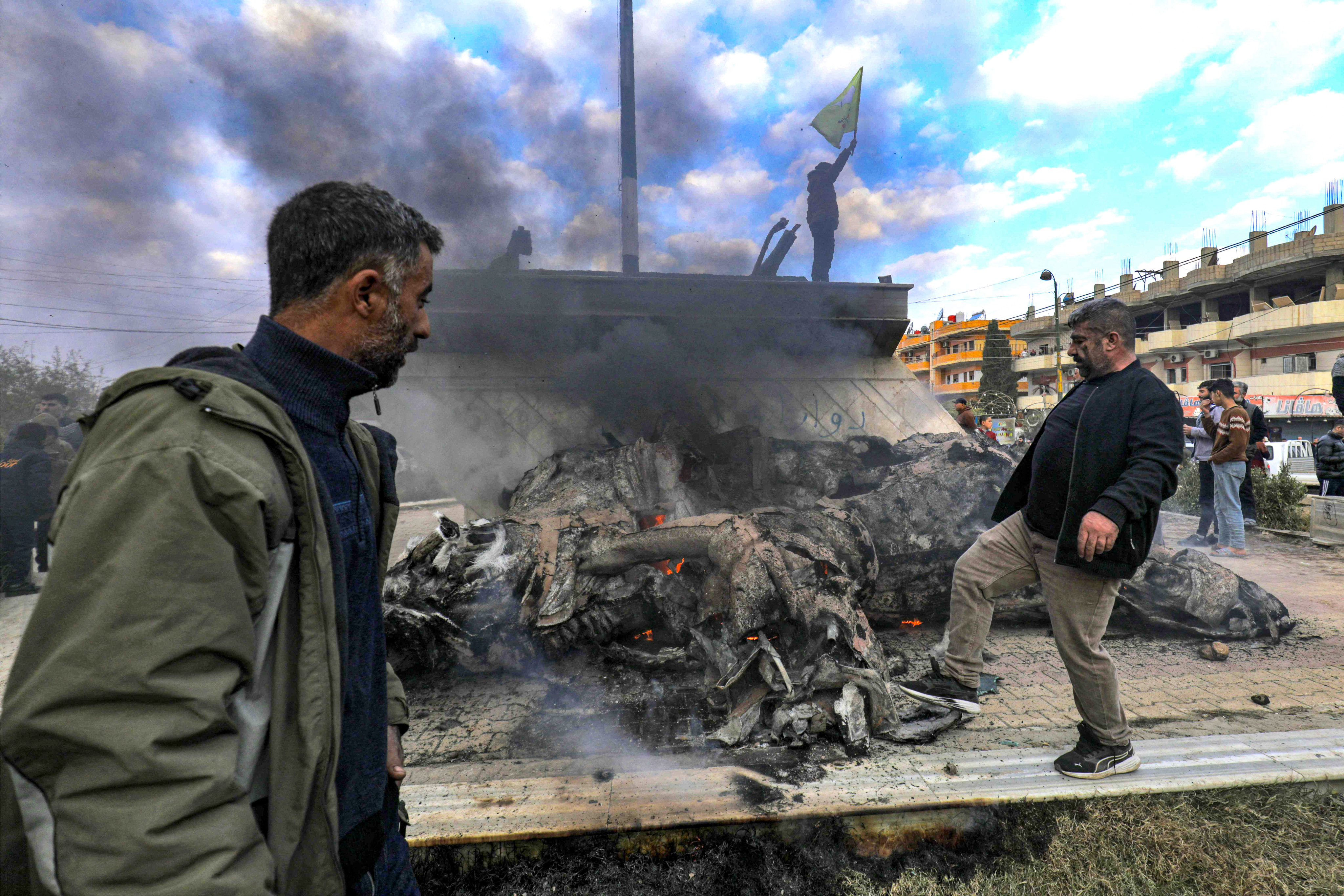 Syrian Kurds destroy the statue of Basel al-Assad, the late elder brother of Syria’s President Bashar al-Assad as they celebrate the fall of capital Damascus to anti-government fighters, in the city of Qamishli on December 8, 2024. Islamist-led rebels declared that they have taken Damascus in a lightning offensive on December 8, sending President Bashar al-Assad fleeing and ending five decades of Baath rule in Syria. Photo: AFP