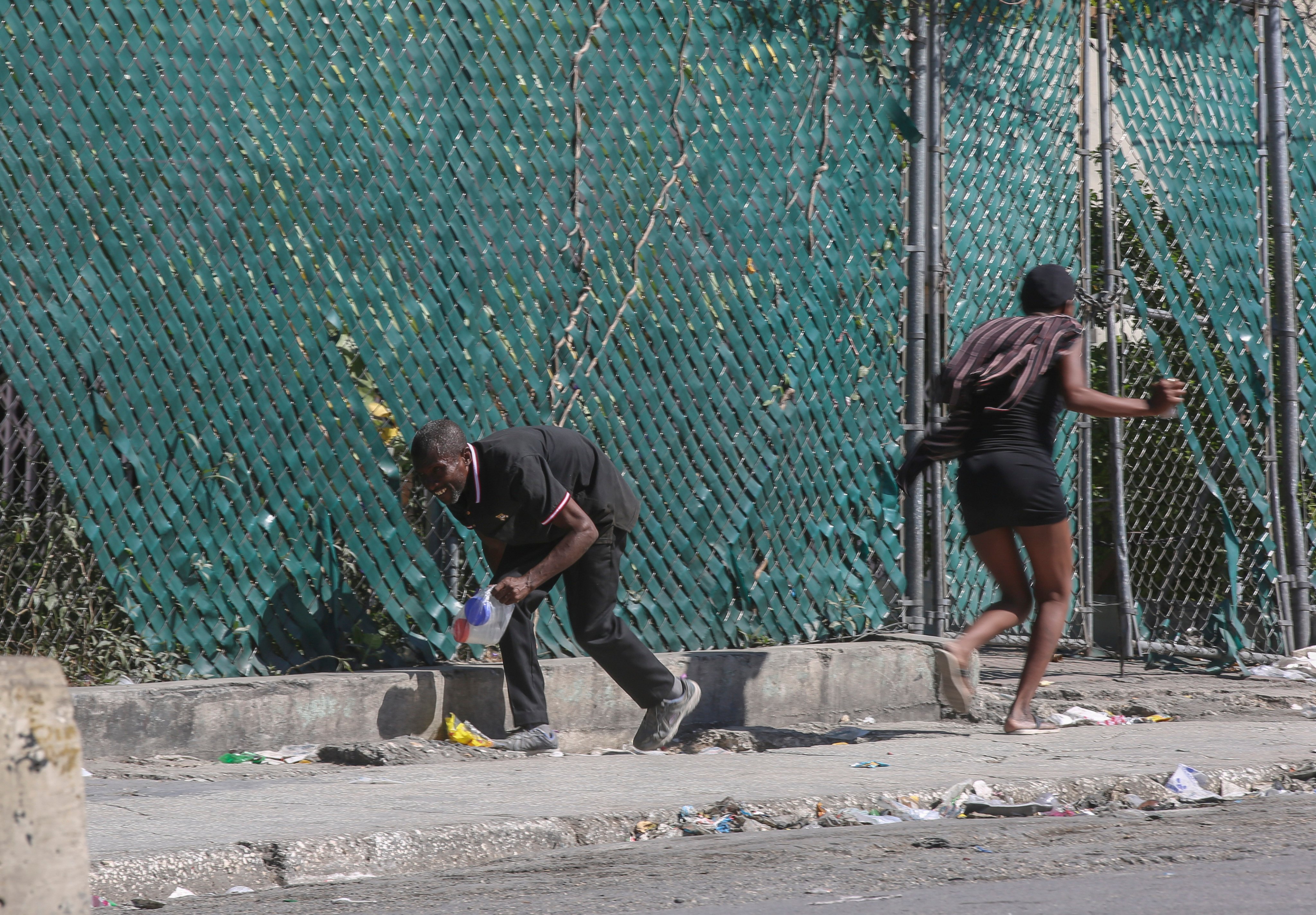 People take cover from gunfire during clashes between police and gangs in the Delmas neighborhood of Port-au-Prince, Haiti, on December 2. Photo: AP