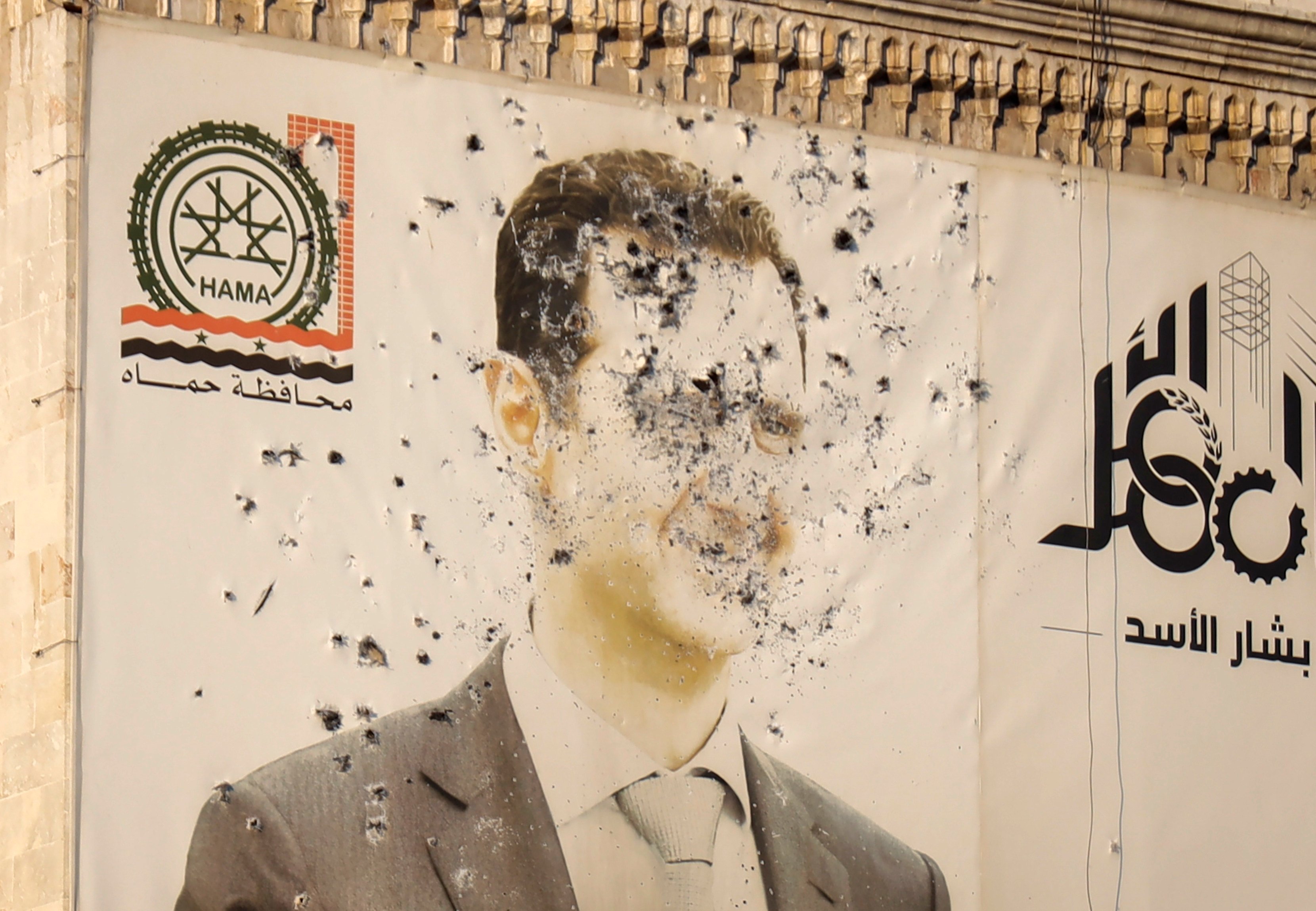 An image of Syrian President Bashar al-Assad, riddled with bullets, on the facade of a government office after the opposition’s takeover of Hama, Syria. Photo: AP