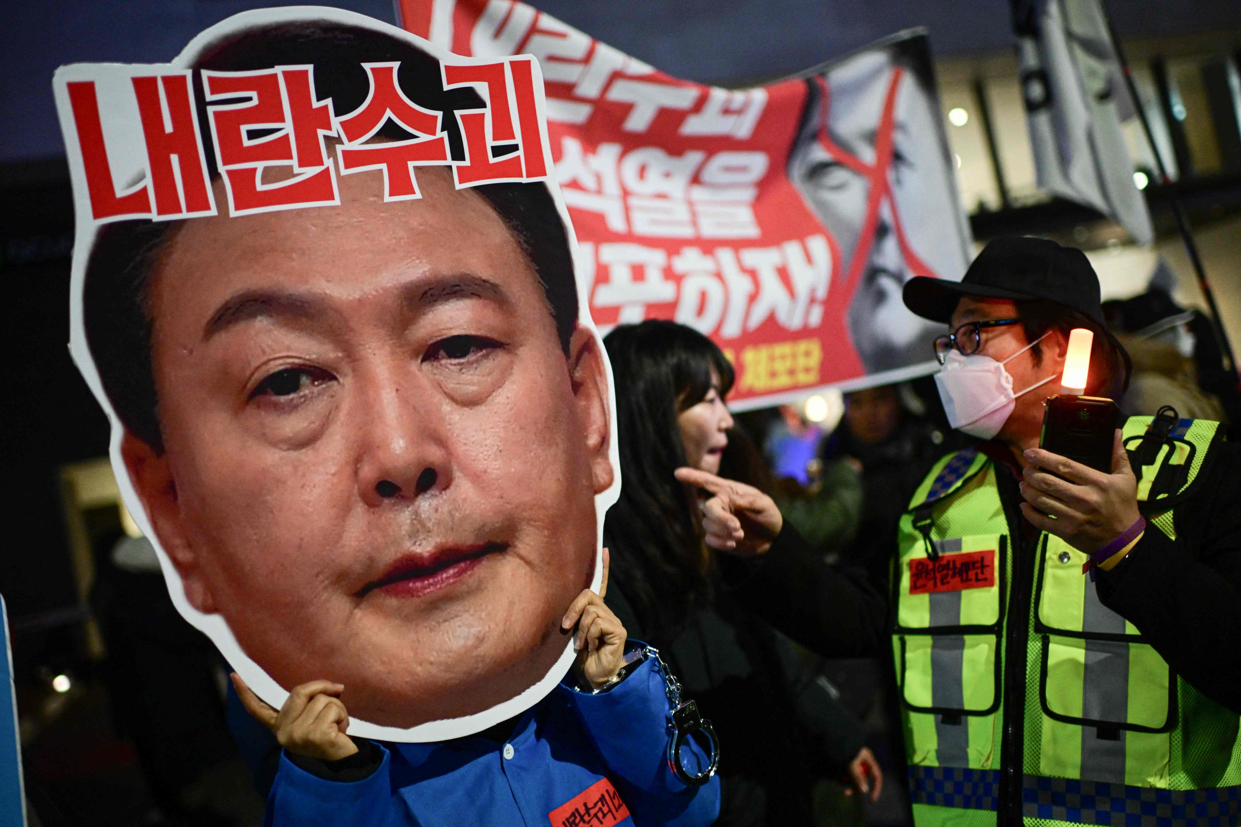 A protester holding a cardboard cut-out of South Korea’s President Yoon Suk-yeol takes part in a demonstration calling for his ouster, outside the National Assembly in Seoul, on December 8. Photo: AFP