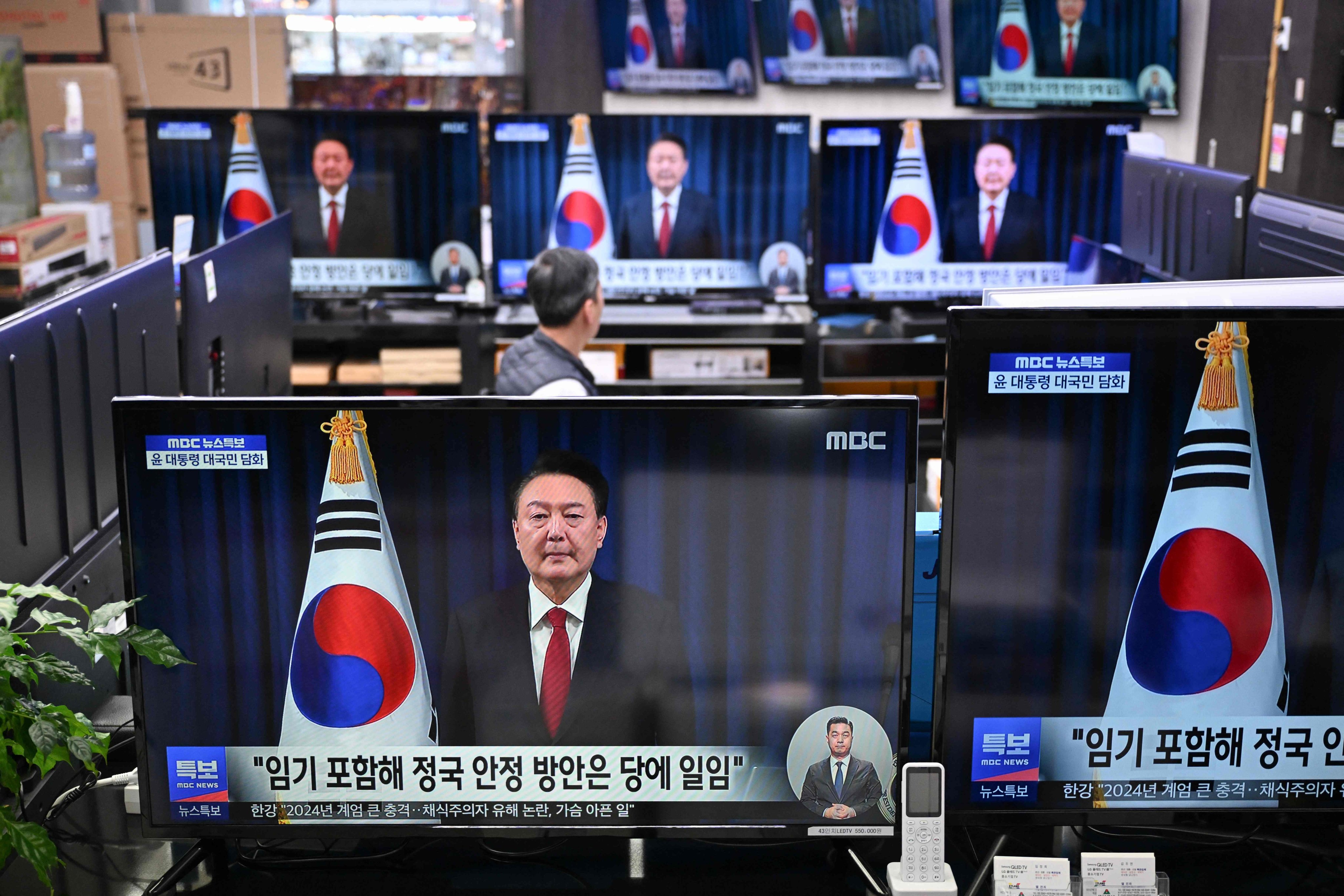 TV screens show footage of an address by South Korea’s President Yoon Suk-yeol, at an electronic market in Seoul on Saturday. Photo: AFP