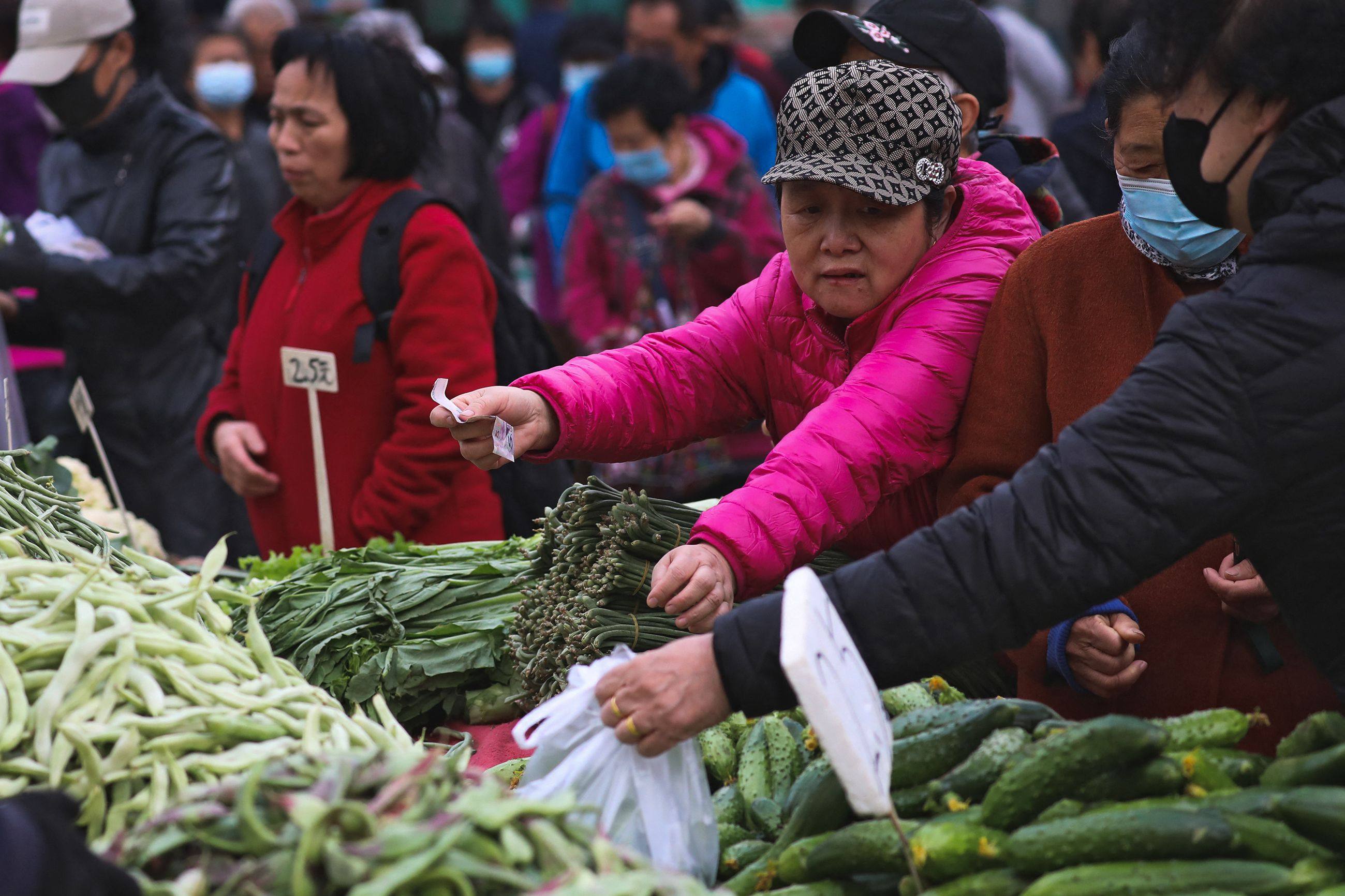 People buy vegetables at a market in Shenyang. Photo: AFP