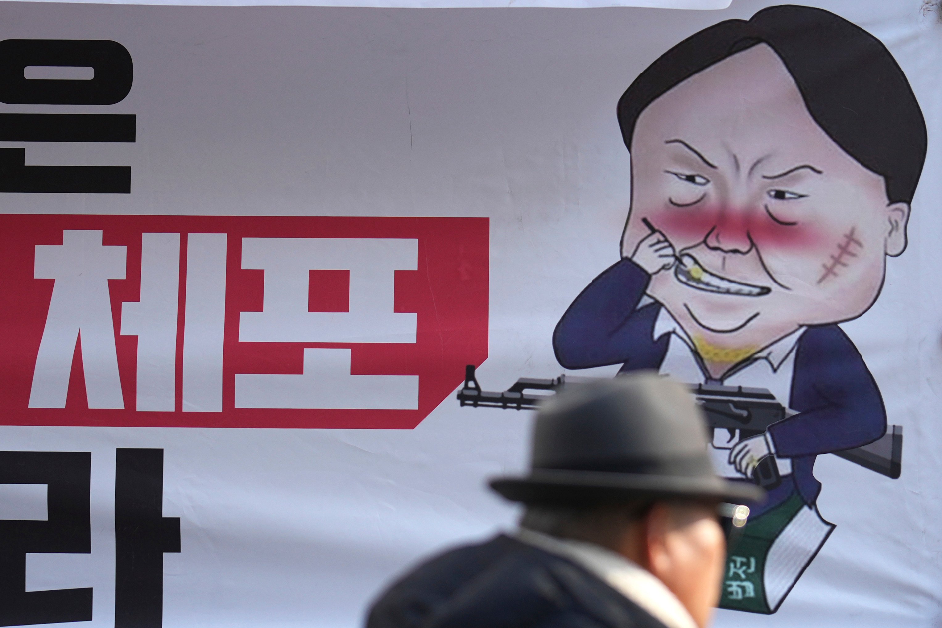 A caricature depicting South Korean President Yoon Suk-yeol is seen near the ruling People Power Party’s head office in Seoul on Monday. The sign reads “Arrest”. Photo: AP