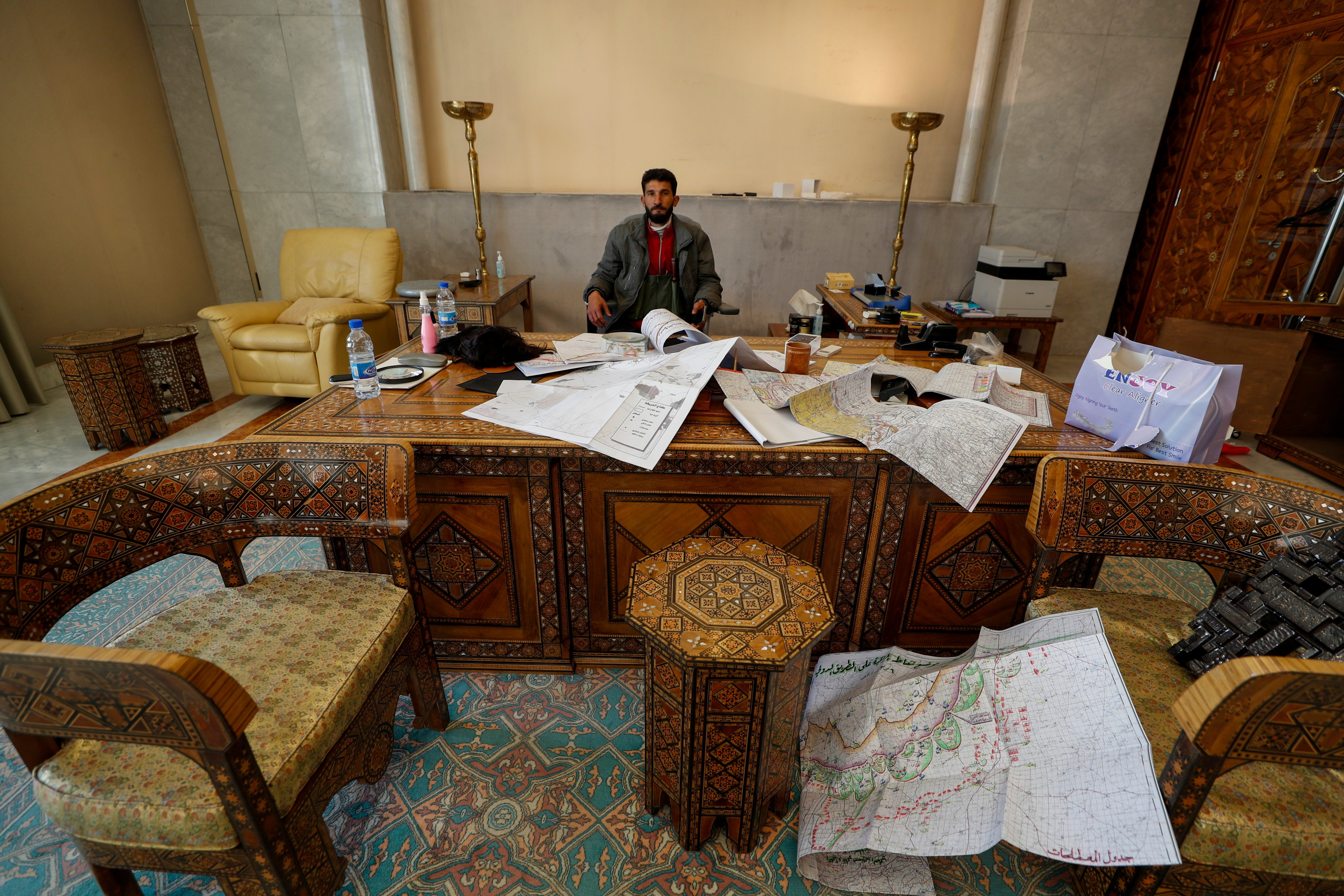 A Syrian opposition fighter sits inside an office at the Presidential Palace in Damascus. Photo: AP