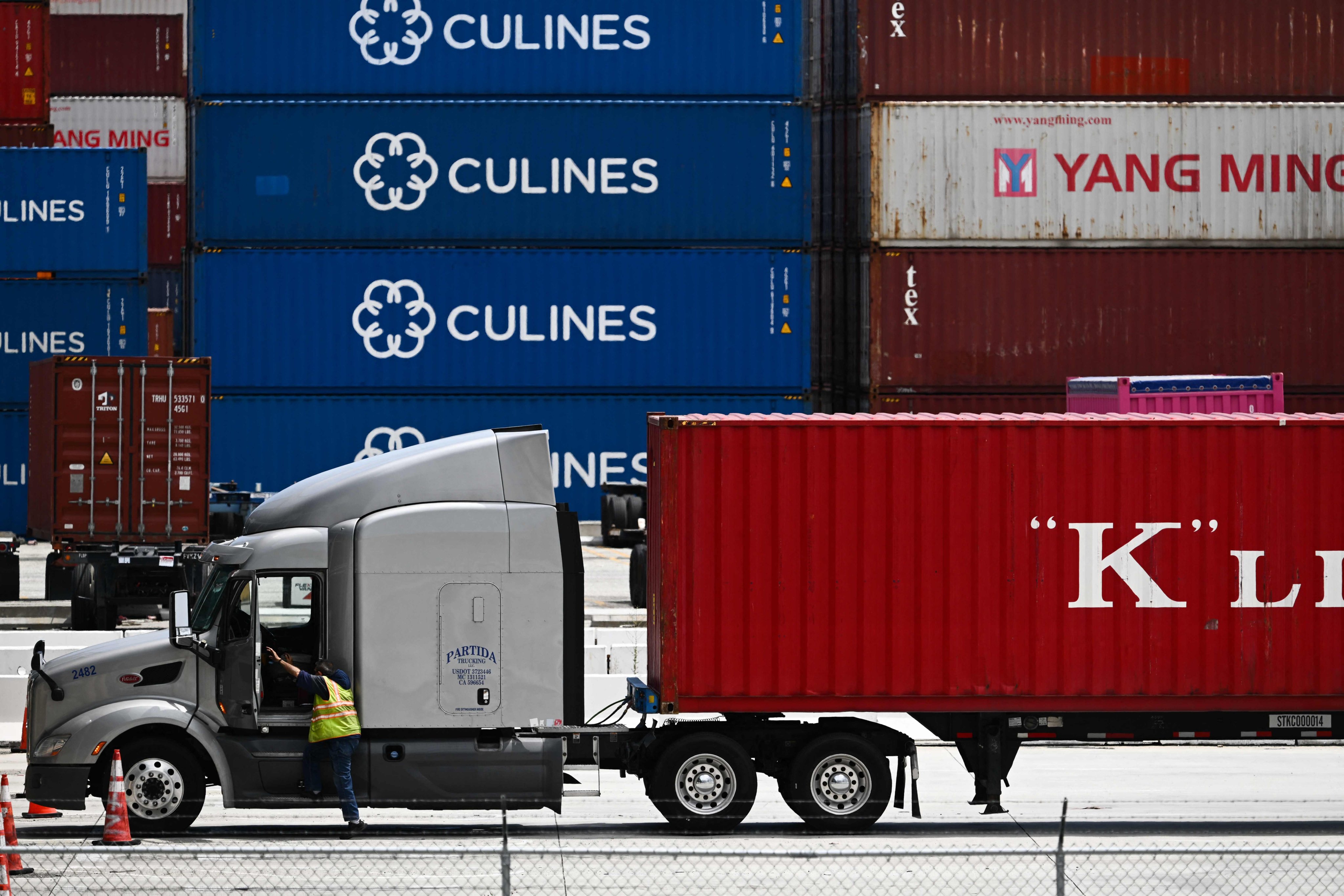 A truck driver prepares to depart with a cargo shipping container from the Port of Los Angeles. Photo: AFP