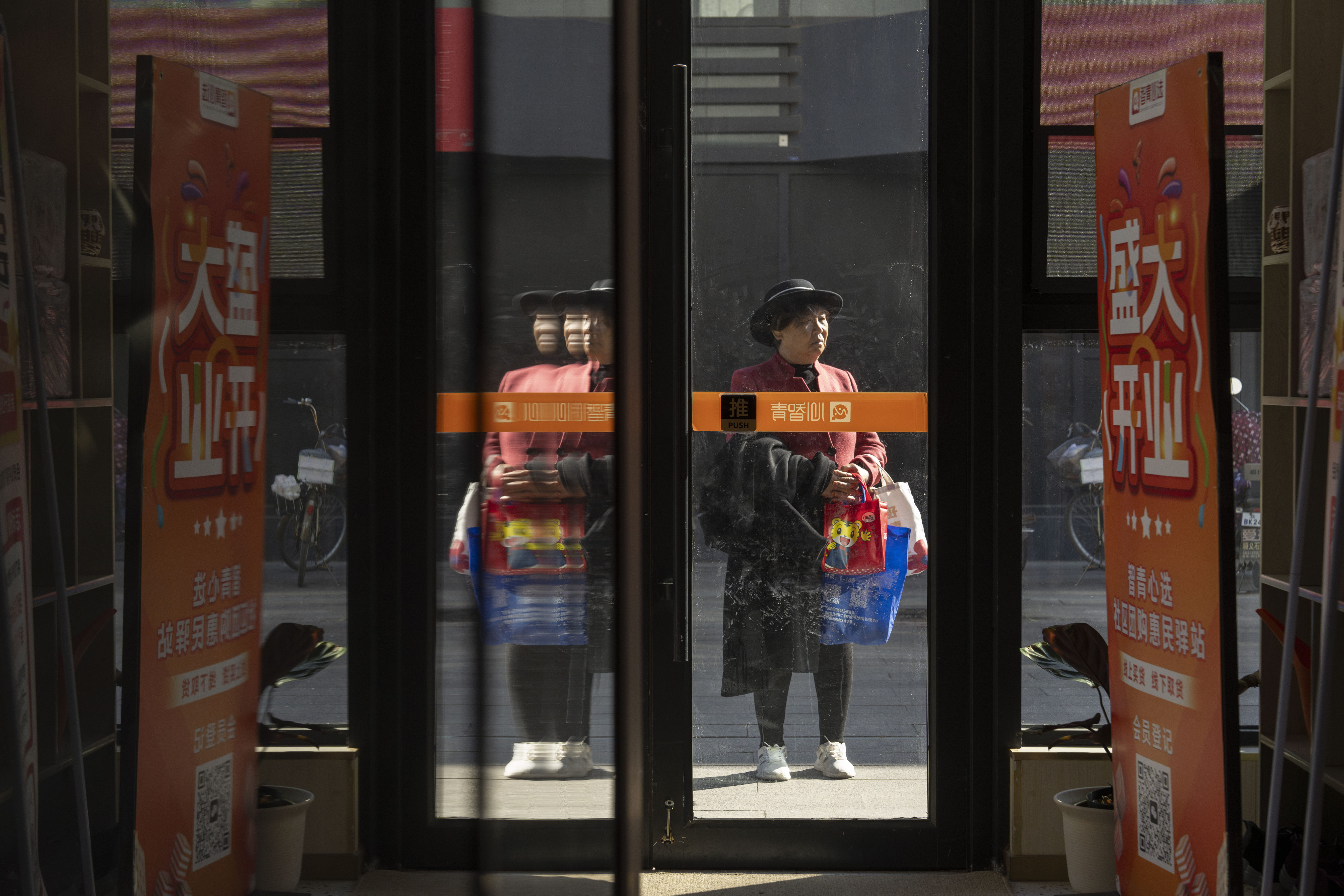 An elderly woman stands at the entrance to the University for the Elderly in Beijing. Photo: AP