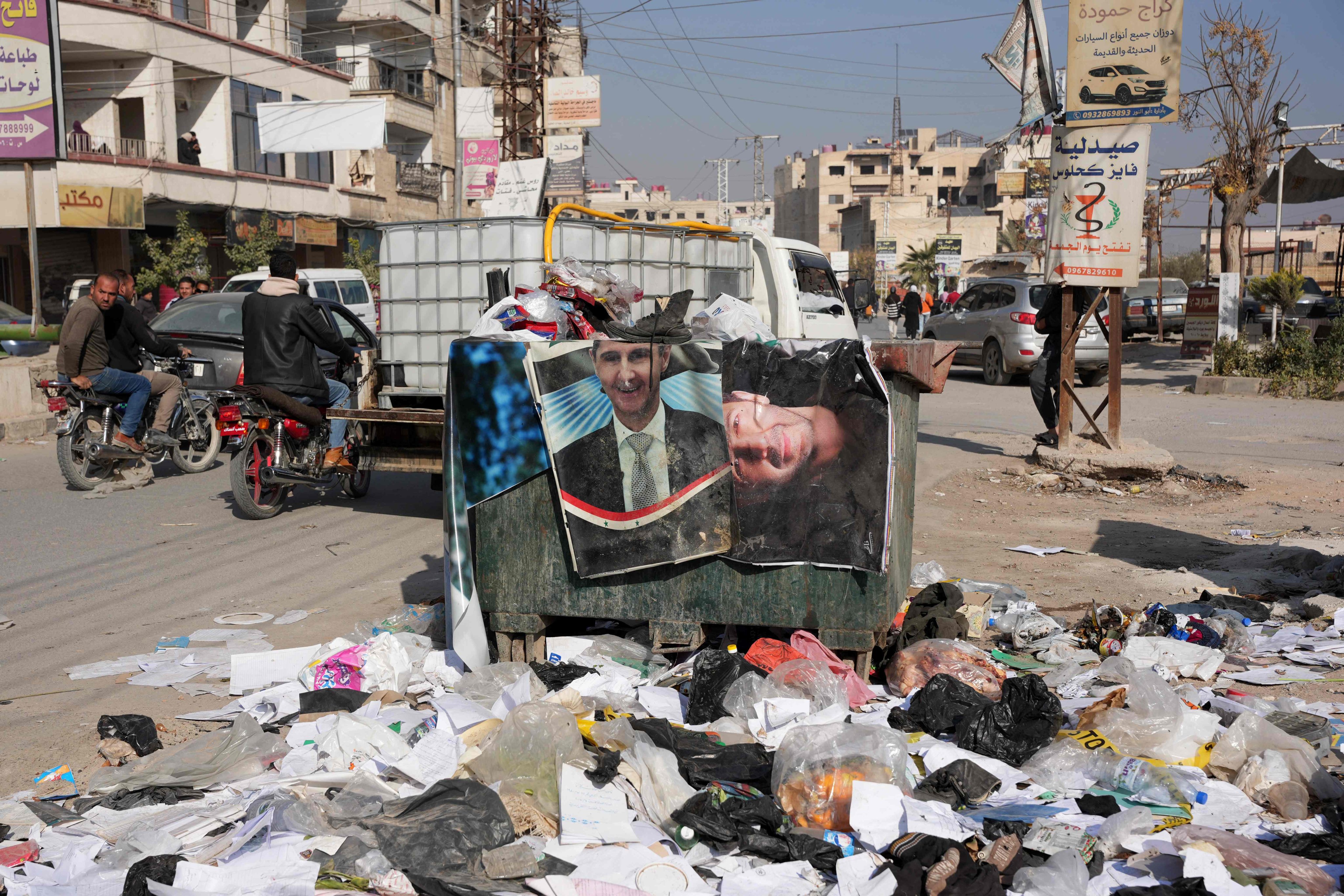 Portraits of ousted Syrian President Bashar al-Assad are dumped in a skip in the Damascus suburb of Daraya. Photo: AFP