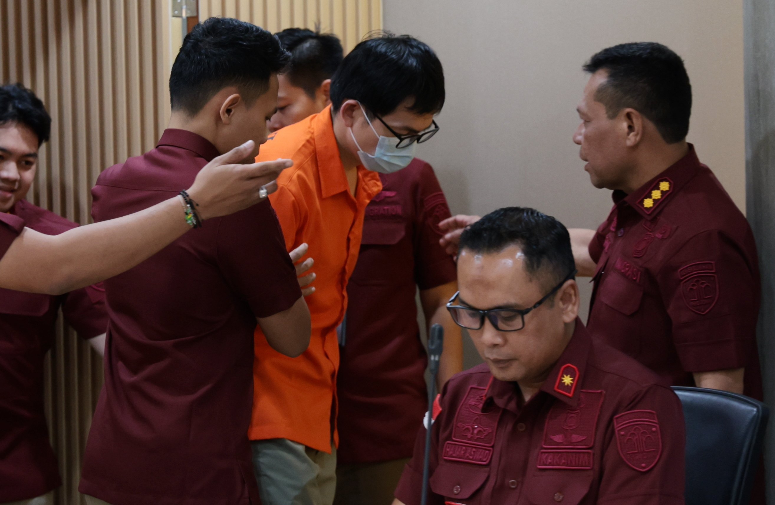 Indonesian immigration officials hold Chinese fugitive Yan Zhangxing (centre) during a press conference in Jakarta on December 5. Photo: EPA-EFE