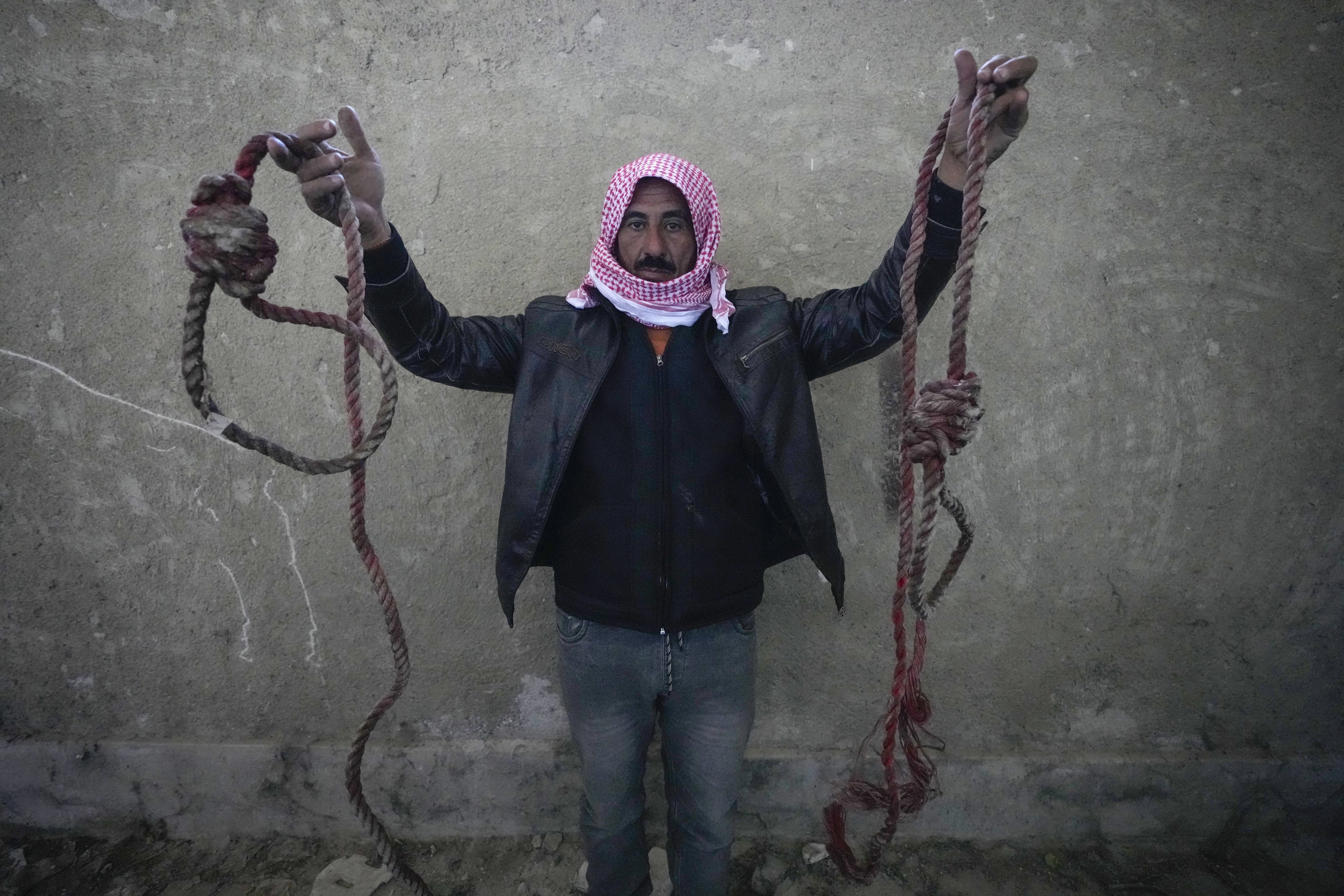 A man shows two ropes tied in the shape of nooses, found in the infamous Sednaya military prison. Photo: AP