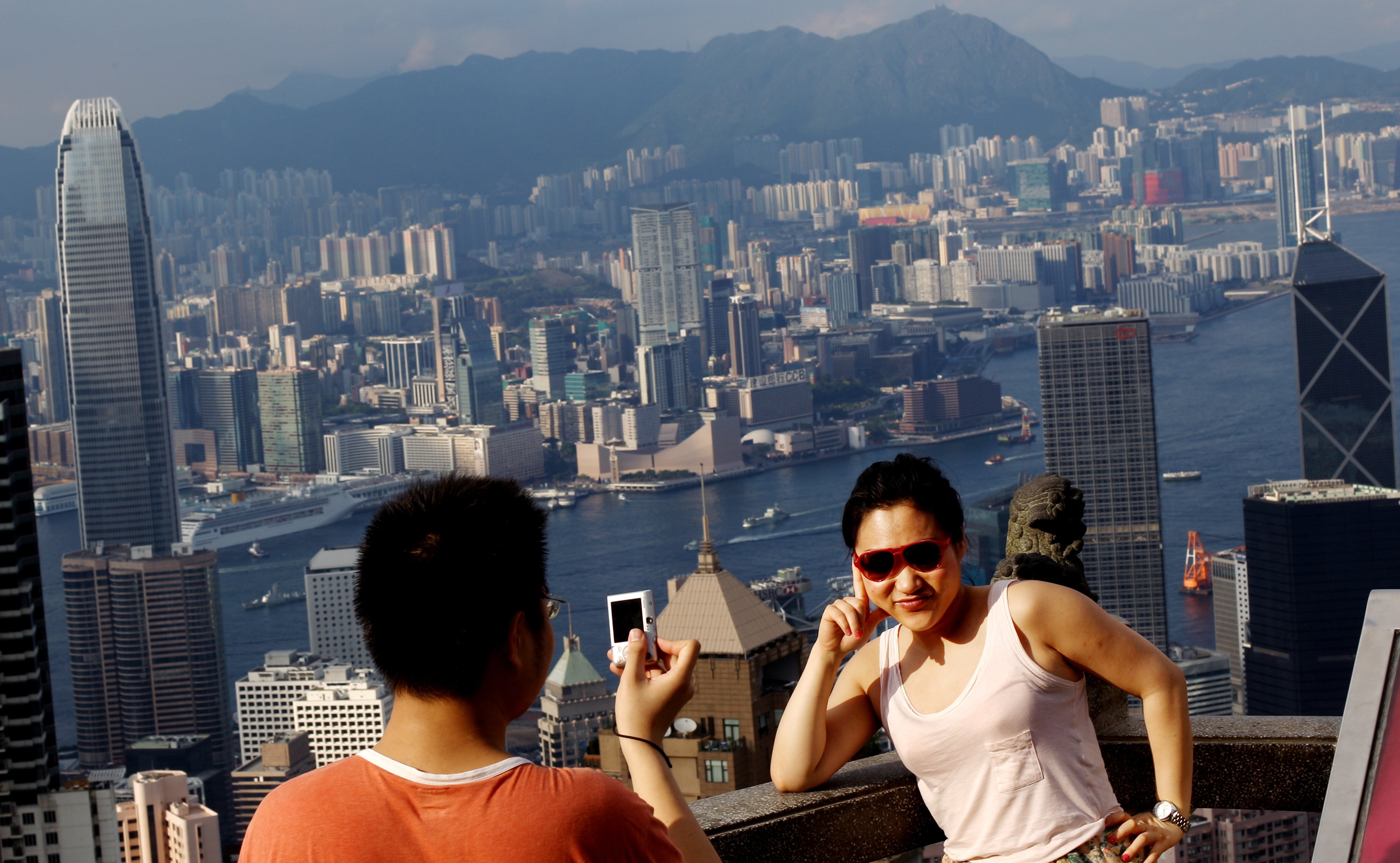 Tourist take photos with the Kowloon skyline and Victoria Harbour from The Peak. Photo: SCMP