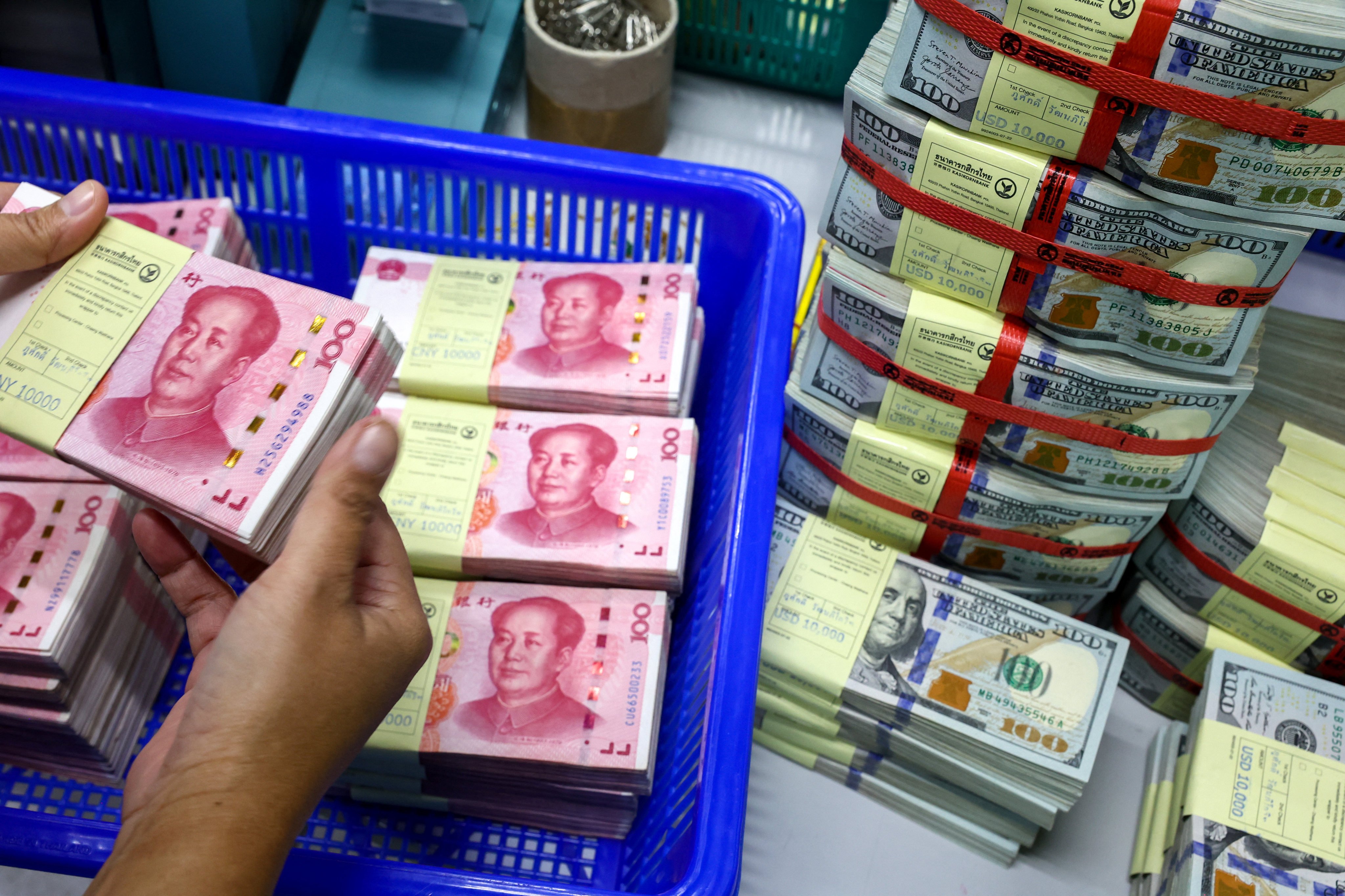 A bank employee count yuan notes next to US dollar notes. Photo: Reuters