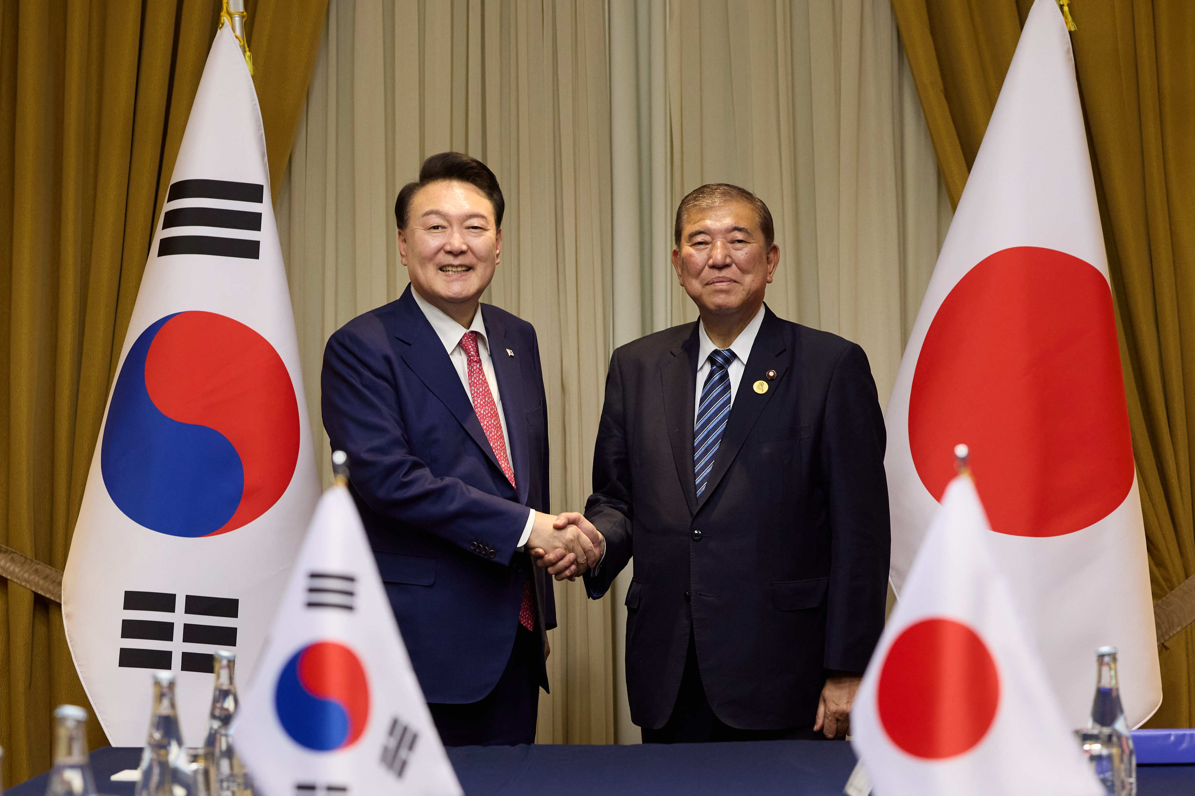 South Korean President Yoon Suk-yeol shakes hands with Japanese Prime Minister Shigeru Ishiba ahead of their meeting on the sidelines of the APEC summit in Lima last month. Photo: dpa