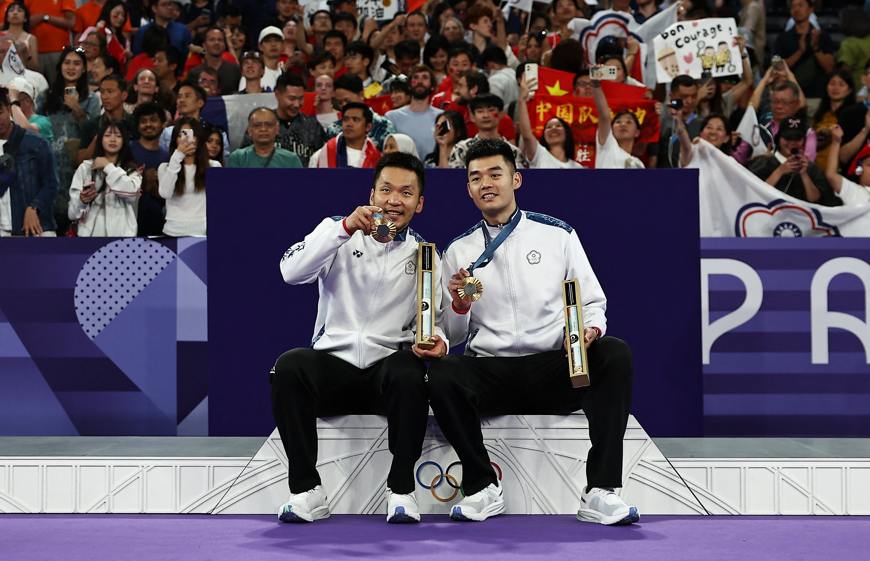 Wang Chin-lin (left) and Lee Yang show off their badminton gold medals at the Paris Olympic Games. Photo: Reuters