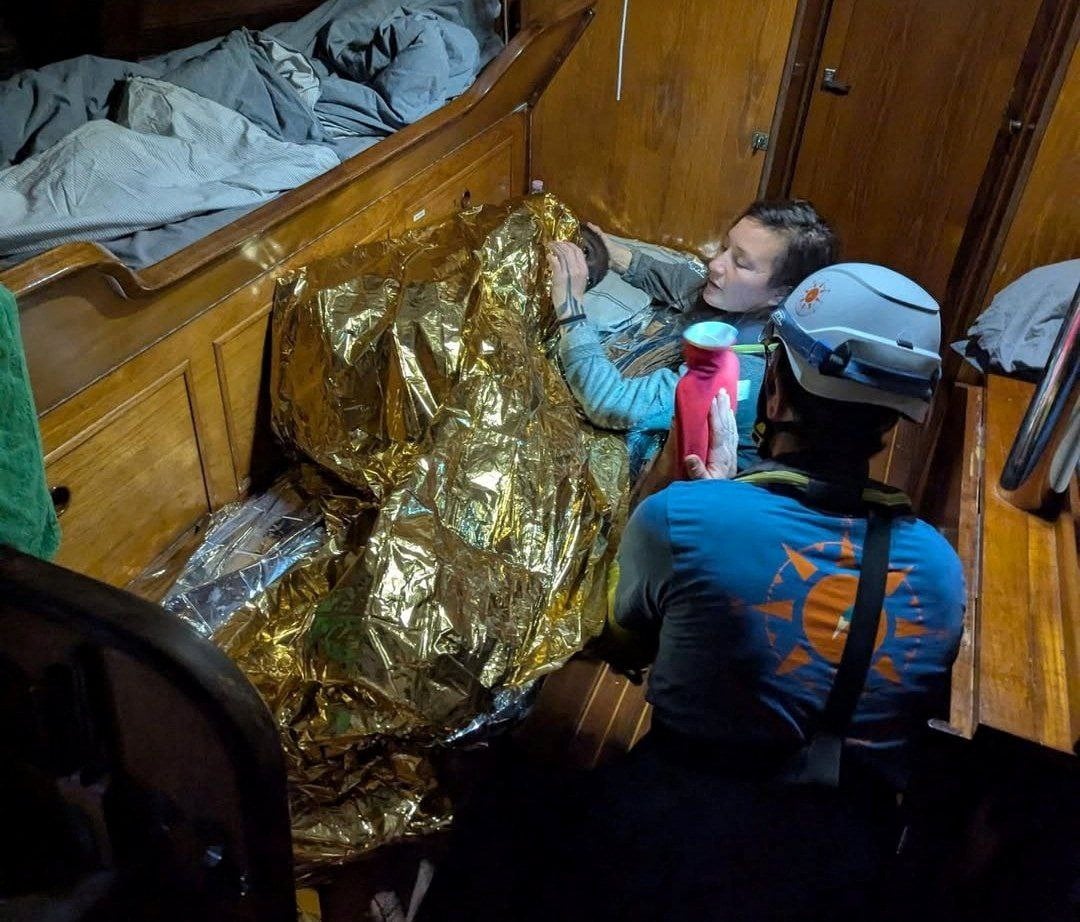 A volunteer assists the girl, the sole survivor of a shipwreck. Photo: Compass Collective via Reuters