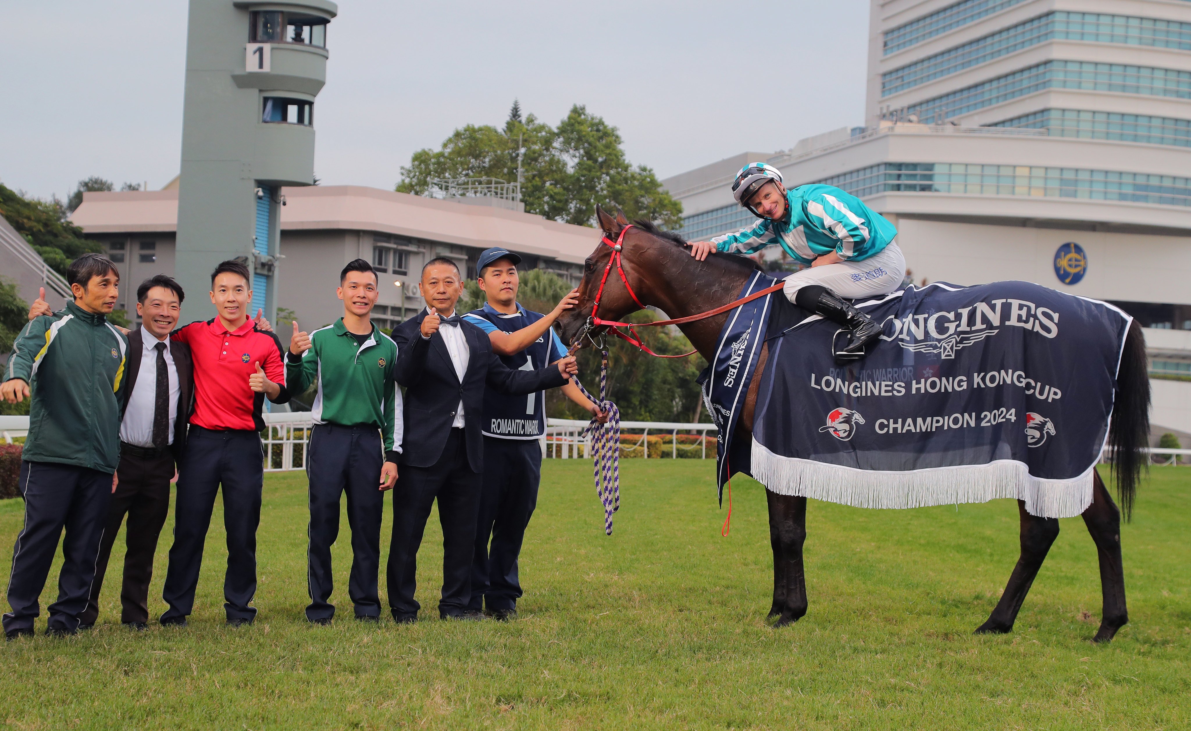 Jockey James McDonald and trainer Danny Shum enjoy Romantic Warrior’s Hong Kong Cup victory with stable staff. Photo: Kenneth Chan