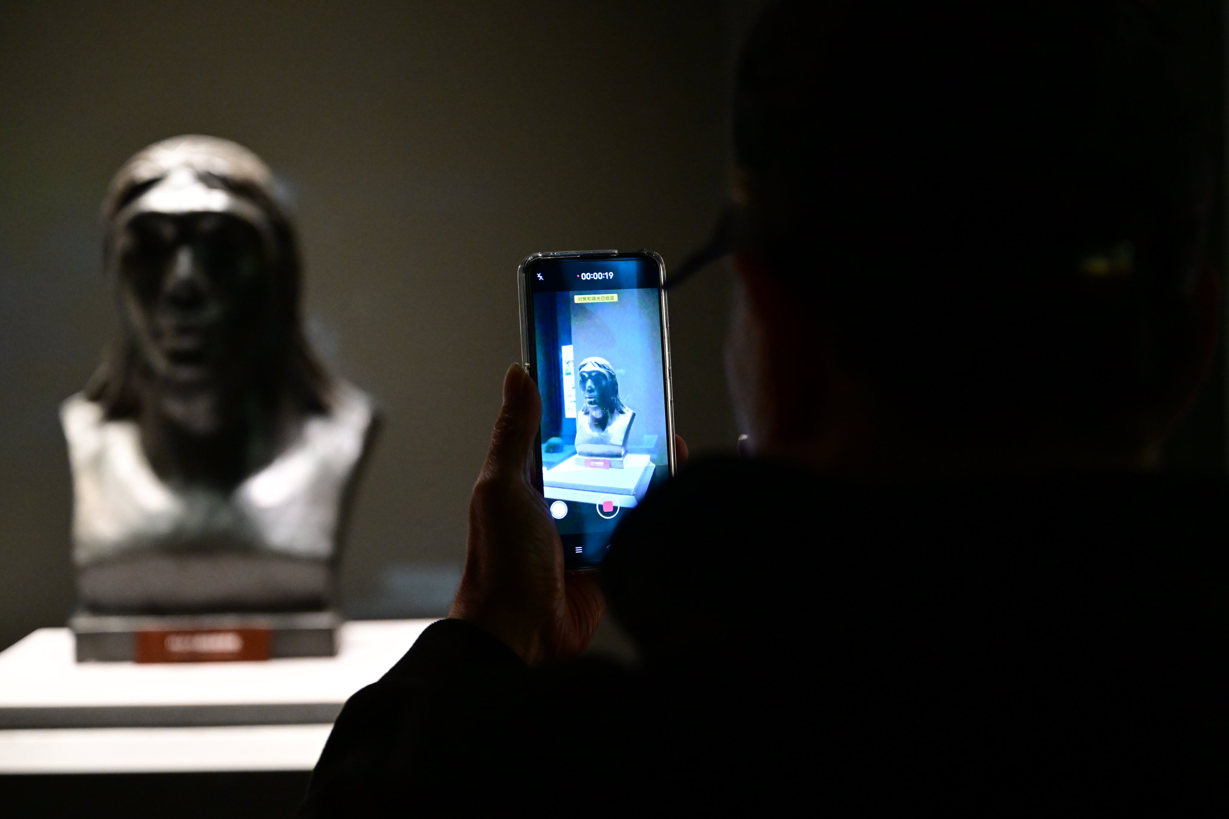 A visitor takes a photo of an exhibit at the Hualongdong site in Dongzhi county, Chizhou, in Anhui province. Photo: Xinhua
